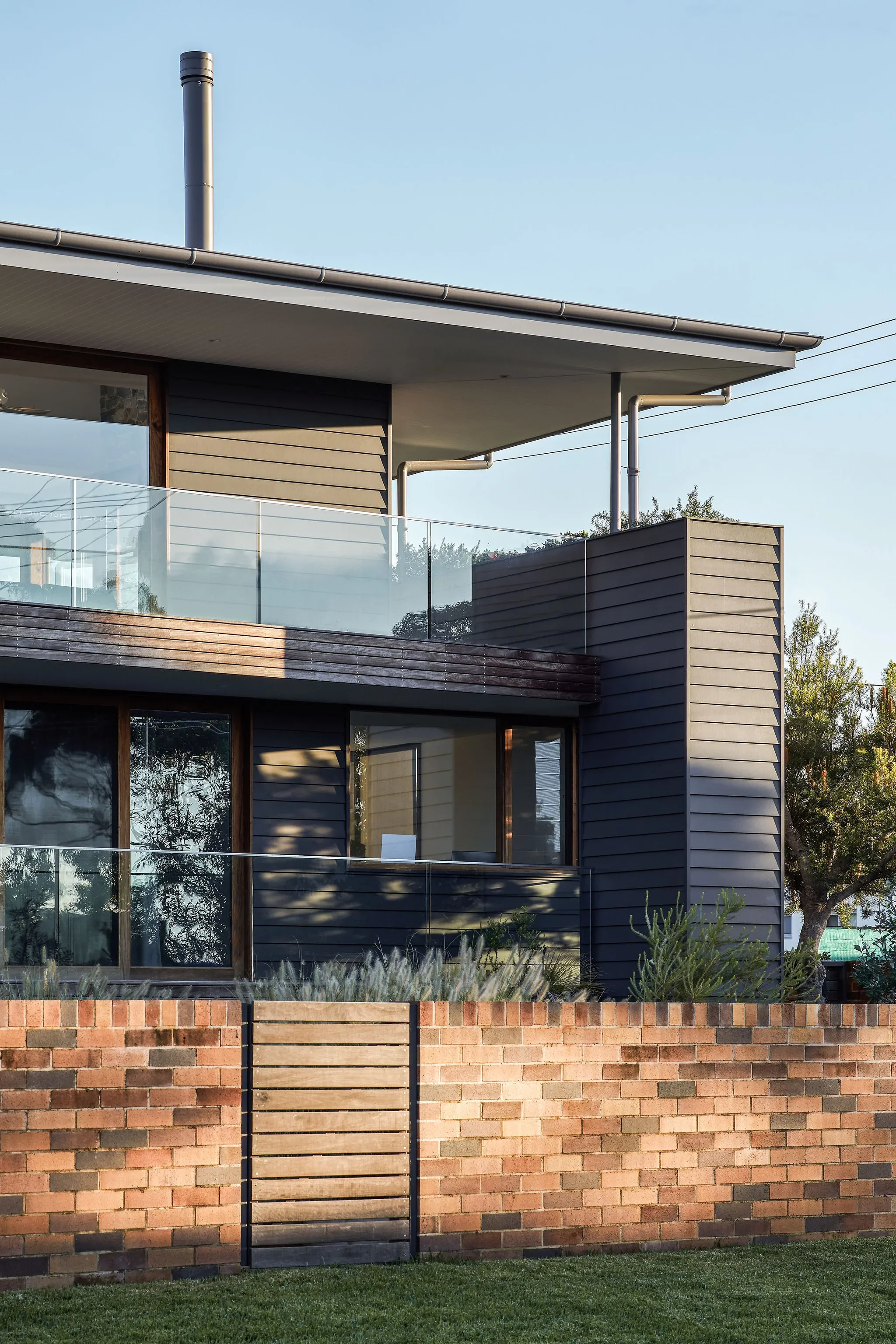 Contemporary residential exterior with layered materials and strong horizontal lines.