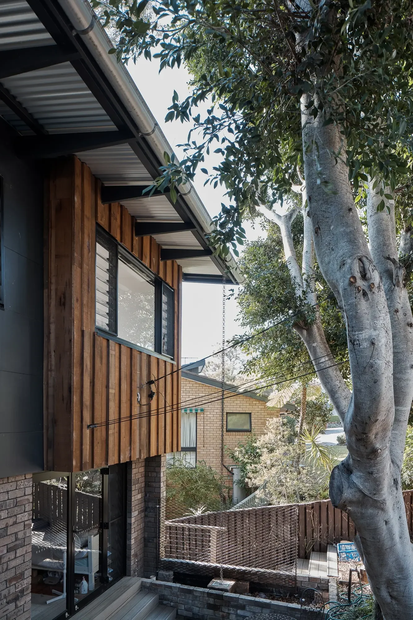 Exterior detail of rainchains in a bushland home in Sydney