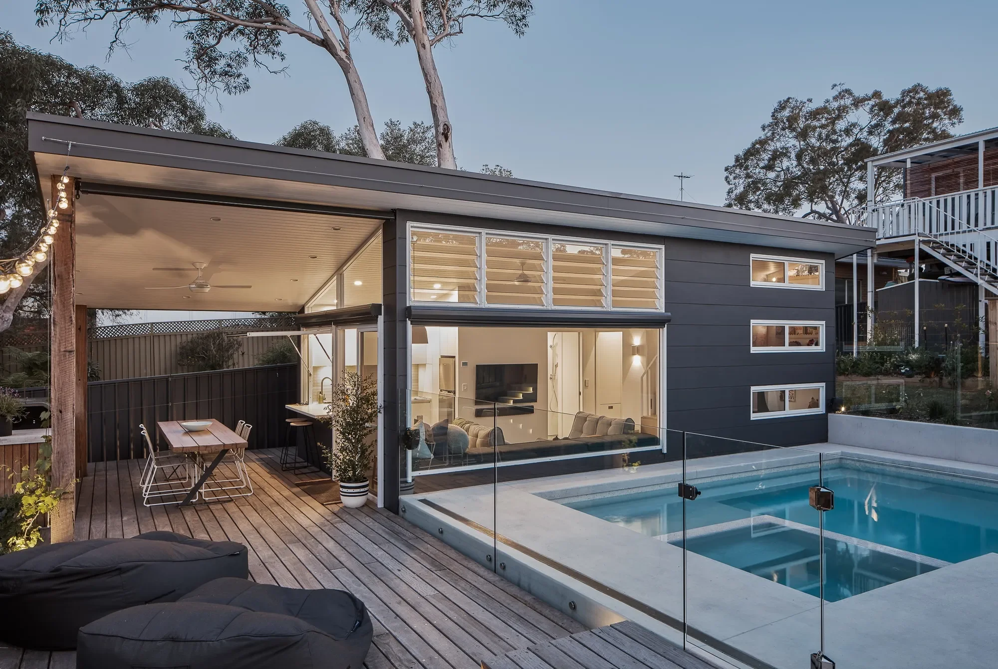 Tiny house exterior at night with pool