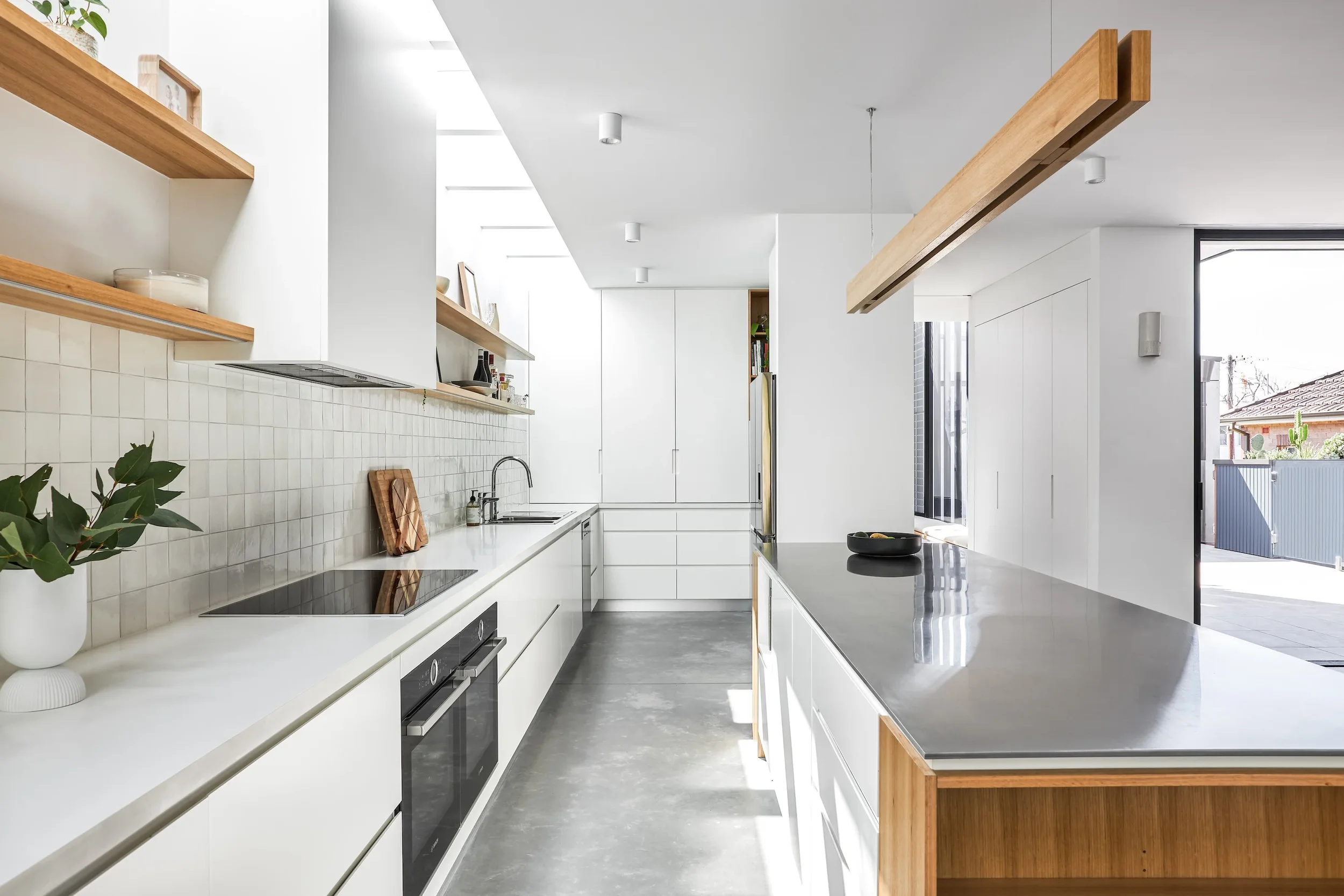 Galley-style kitchen with clean lines, timber accents and integrated appliances