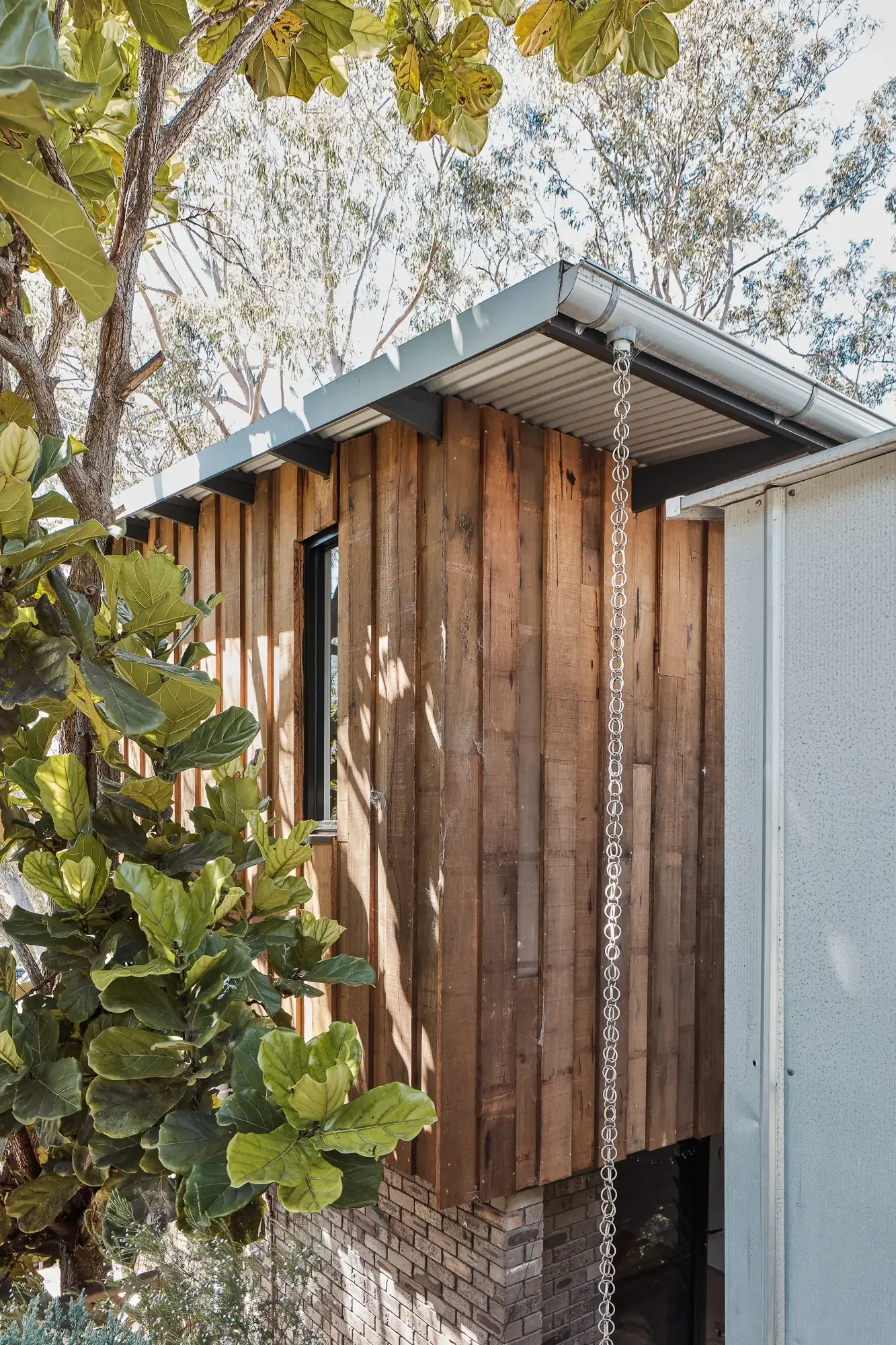 Vertical timber cladding with rainchains on modern home addition