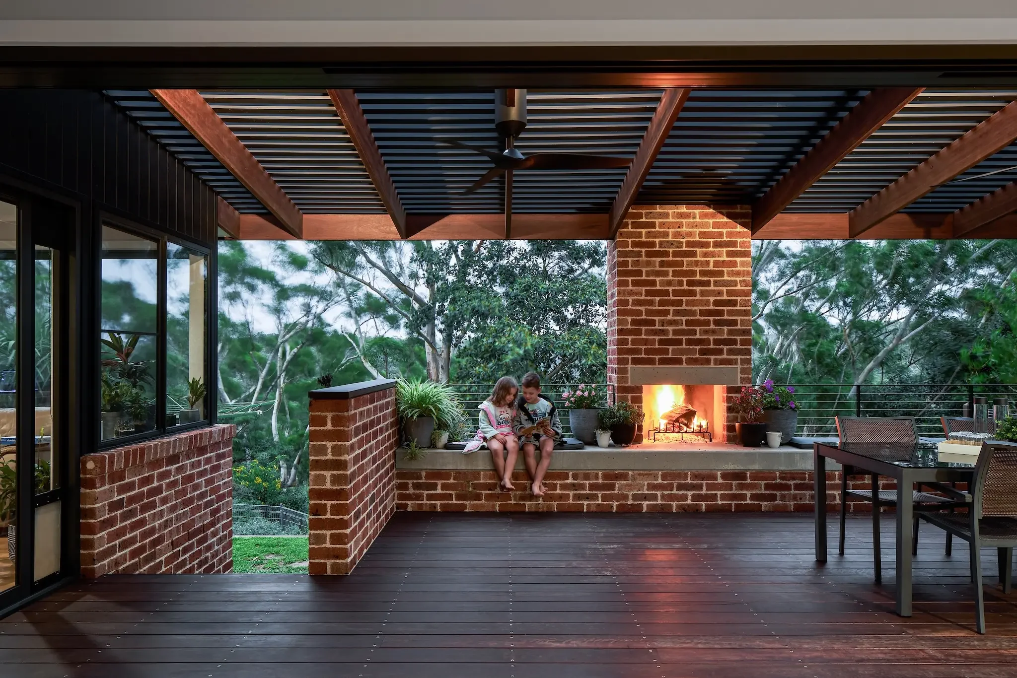Outdoor living area with fireplace at dusk