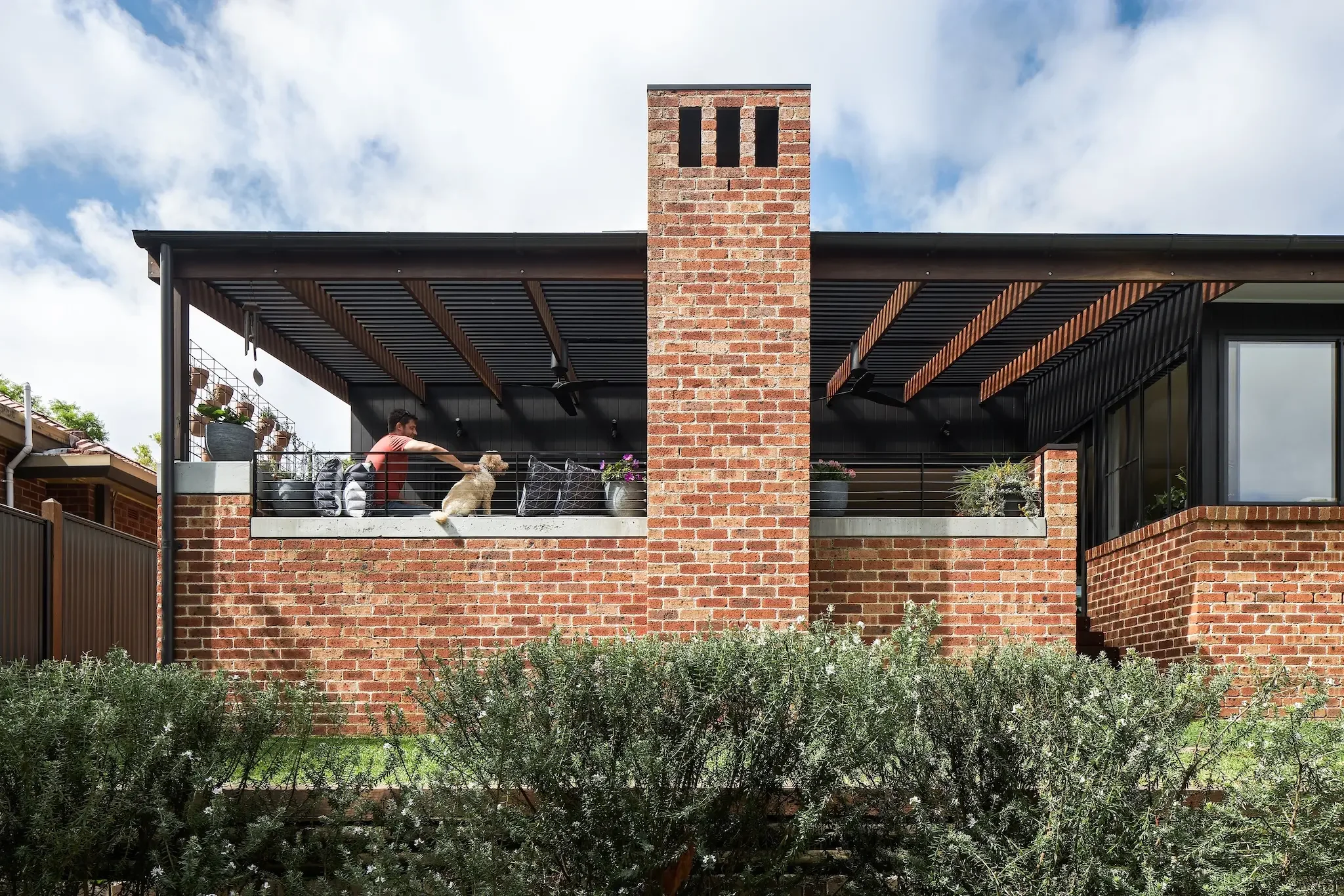 Outdoor terrace with brick fireplace and timber pergola