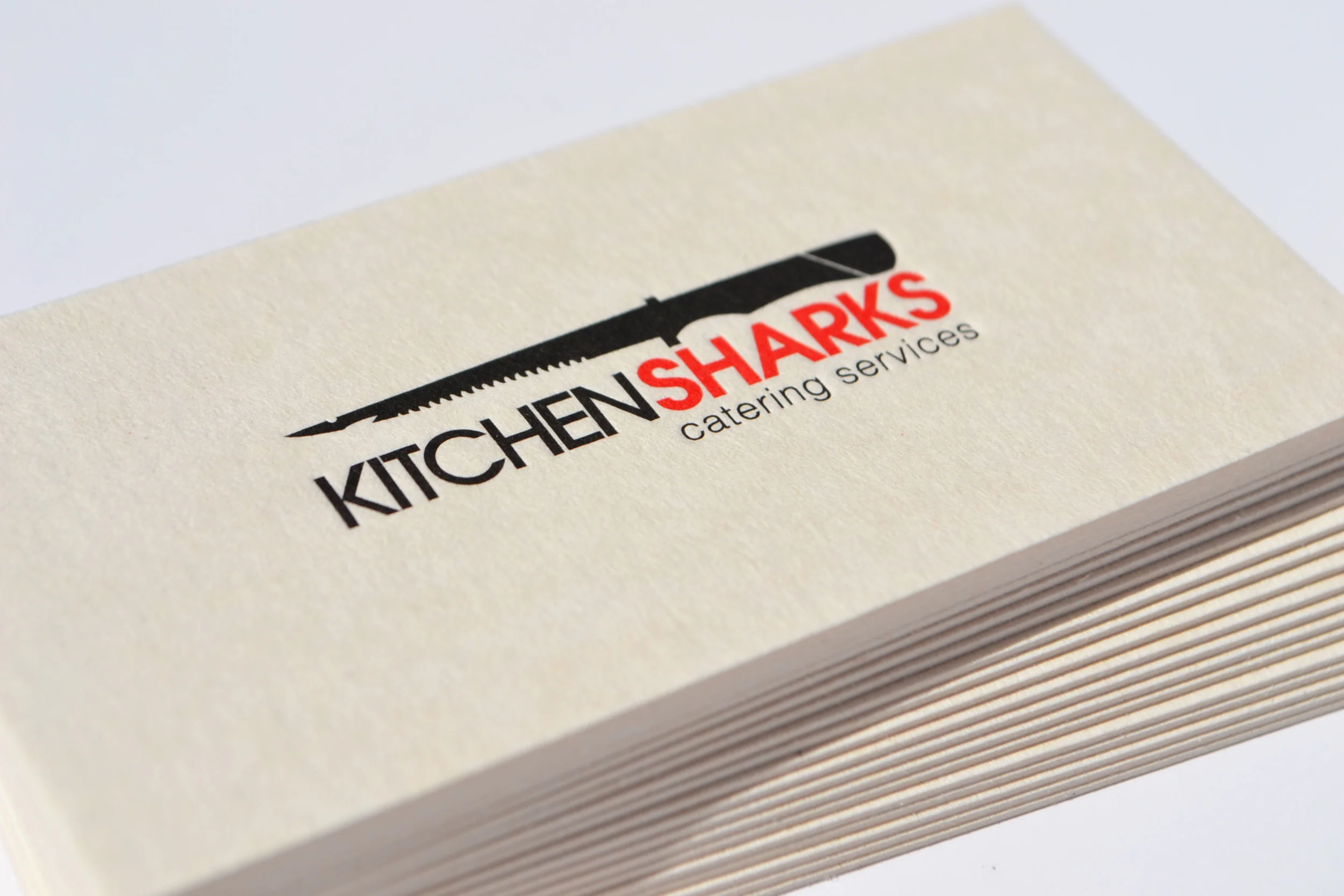  Kitchen Sharks is a catering company owned by two chefs who competed in the international TV show, ‘Top Chef’. The name and logo were selected based on the personalities of the two chefs.&nbsp;They were printed on a 430gr beermat board with logo deb