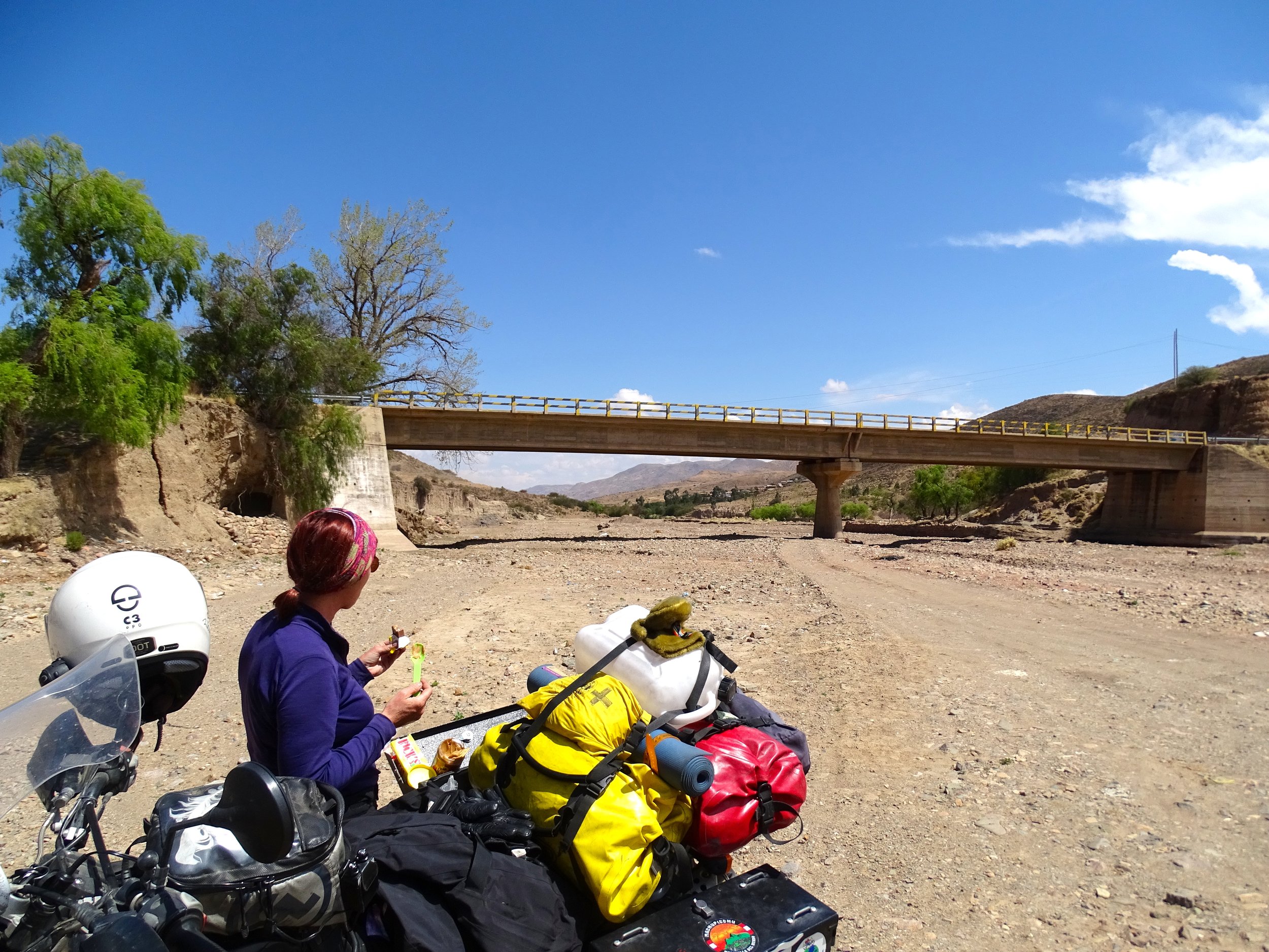 Taking a break for a snack, at our self-created "rest area" on the road in Bolivia.