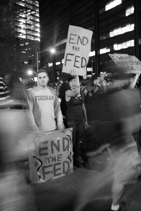 8 October 2011 In Zuccotti park, lined-up protesters hold signs in front of passersby.