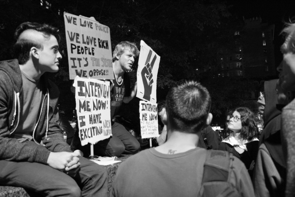8 October 2011 “Interview me now to find out what this is all about and where it is headed!!” says the lower right-hand sign. The young man kneeling over between the signs had a hoarse voice after a day of screaming.