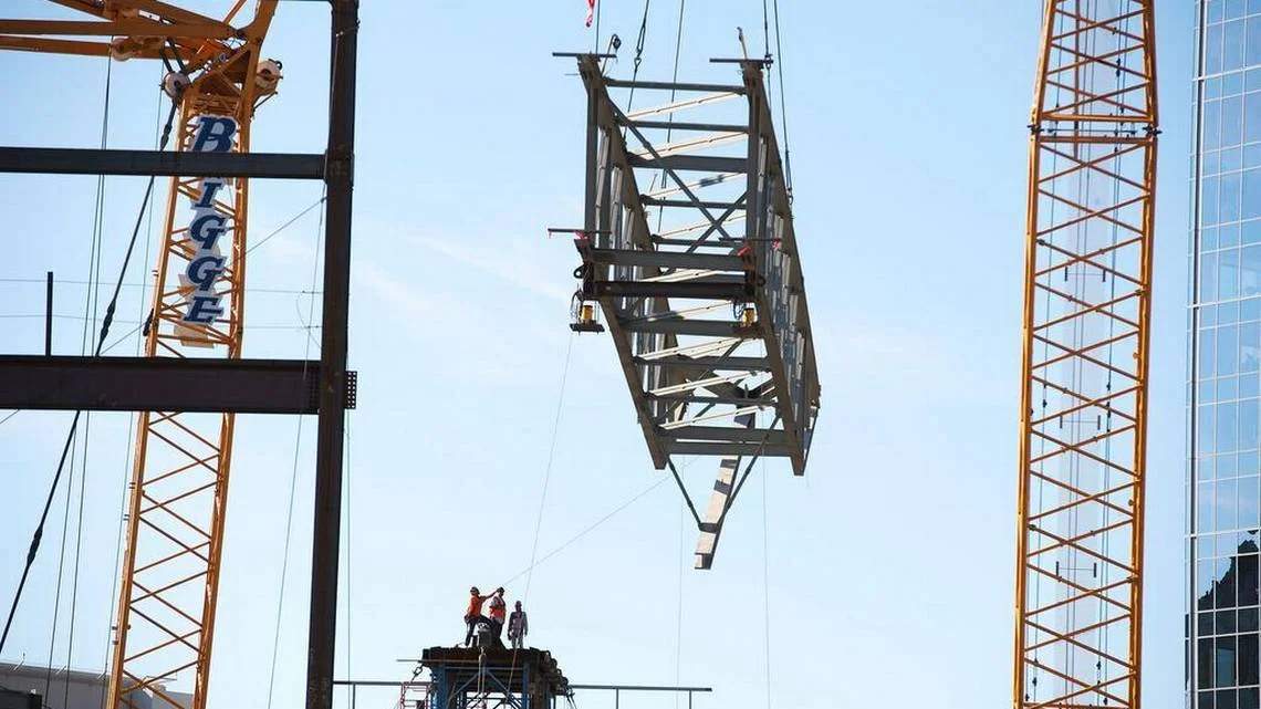 Workers slowly guide the first major section of the roof trusses at the Golden 1 Center on Monday. in downtown Sacramento. The 120-foot-long truss weighs 90,000 pounds and is the first of six major trusses to be lowered into place by a large crane. Approximately 180 workers fabricated the trusses in Schuff Steel's Stockton facility. Construction of the Golden 1 Center is on time and the arena is scheduled to open in October 2016.
