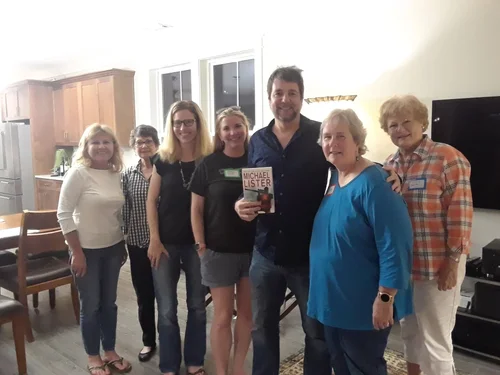 Michael Lister with a book club, holding one of his books