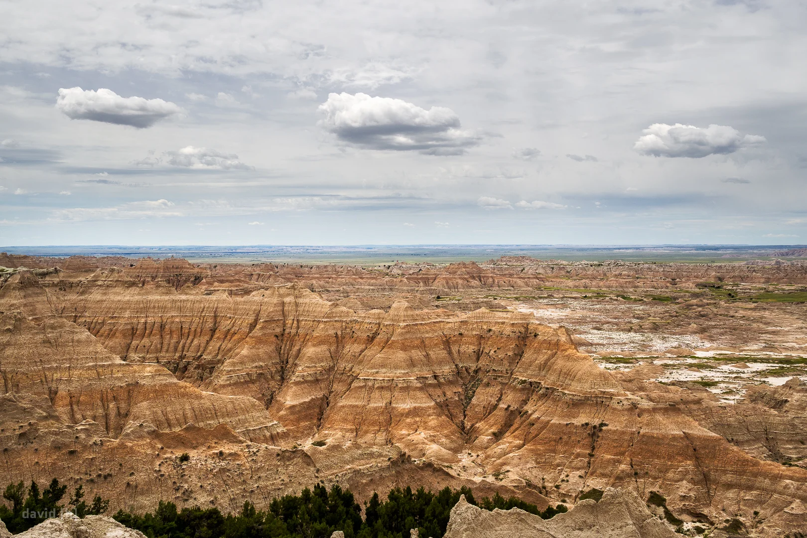 The eroded ridges and spires unveil the many different layers of rock and soil usually concealed beneath the grasslands of Badlands.