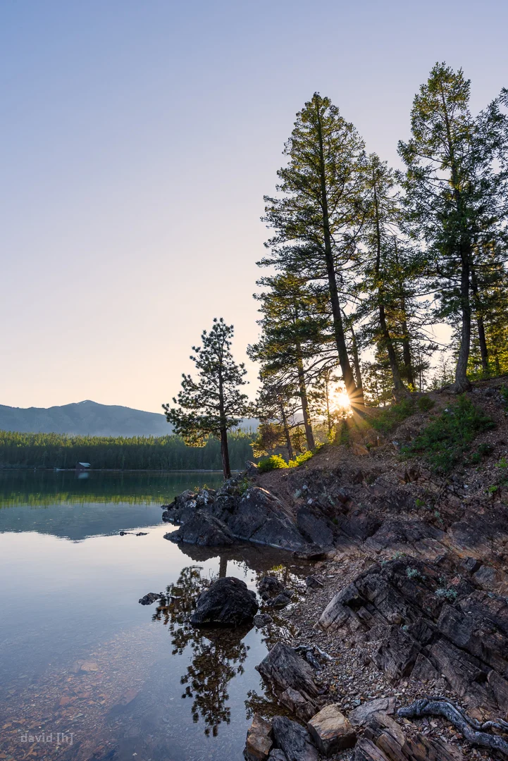 The sun is setting behind Rocky Point at Lake McDonald in Glacier National Park - no clouds in sight, but still beautiful.