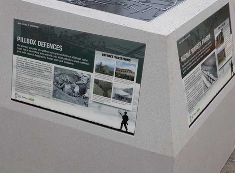 GRP interpretation panels around the side of the concrete marker.