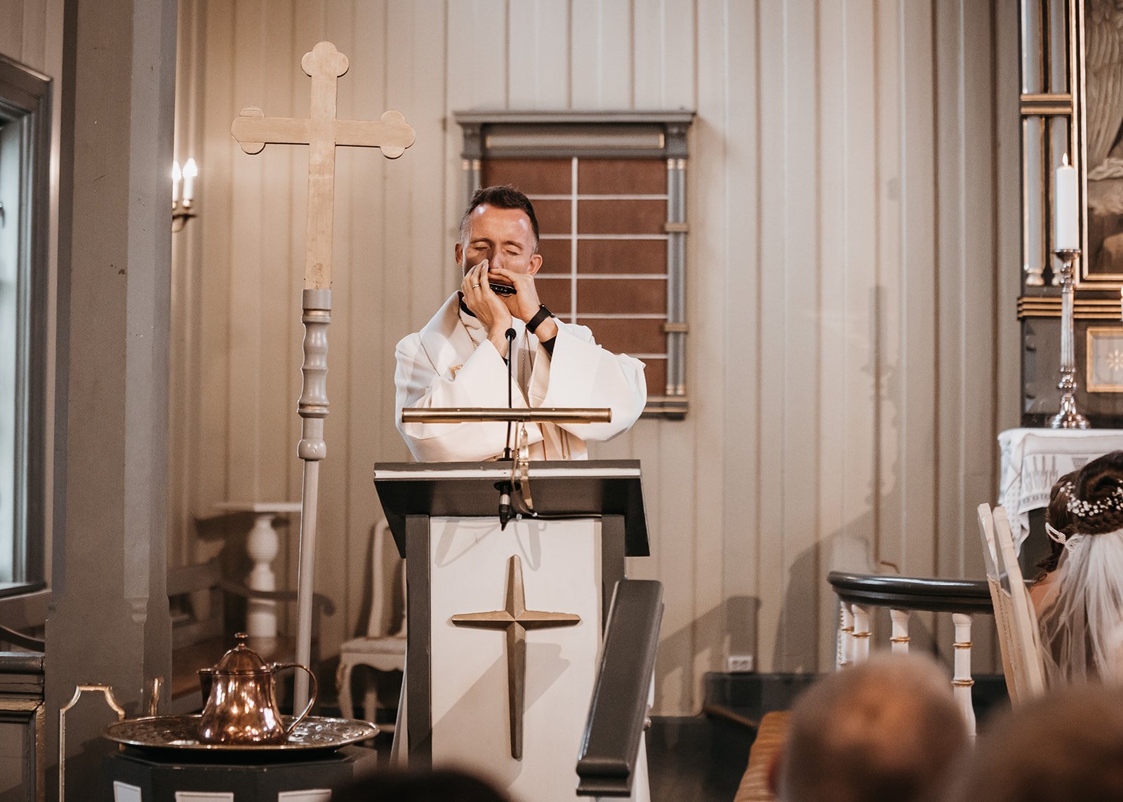Presten spiller munnspill i vielsen i Birkeland kirke