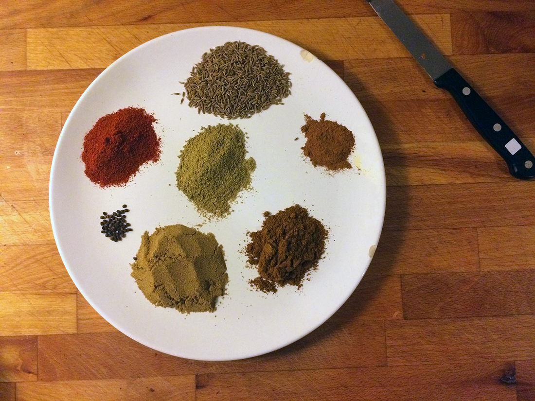 The spices. Starting from left Chili powder (red one), Cumin seeds, Cinnamon powder, Garam Masala, Corriander powder, Cardamom seeds and Fennel powder (in the middle.)