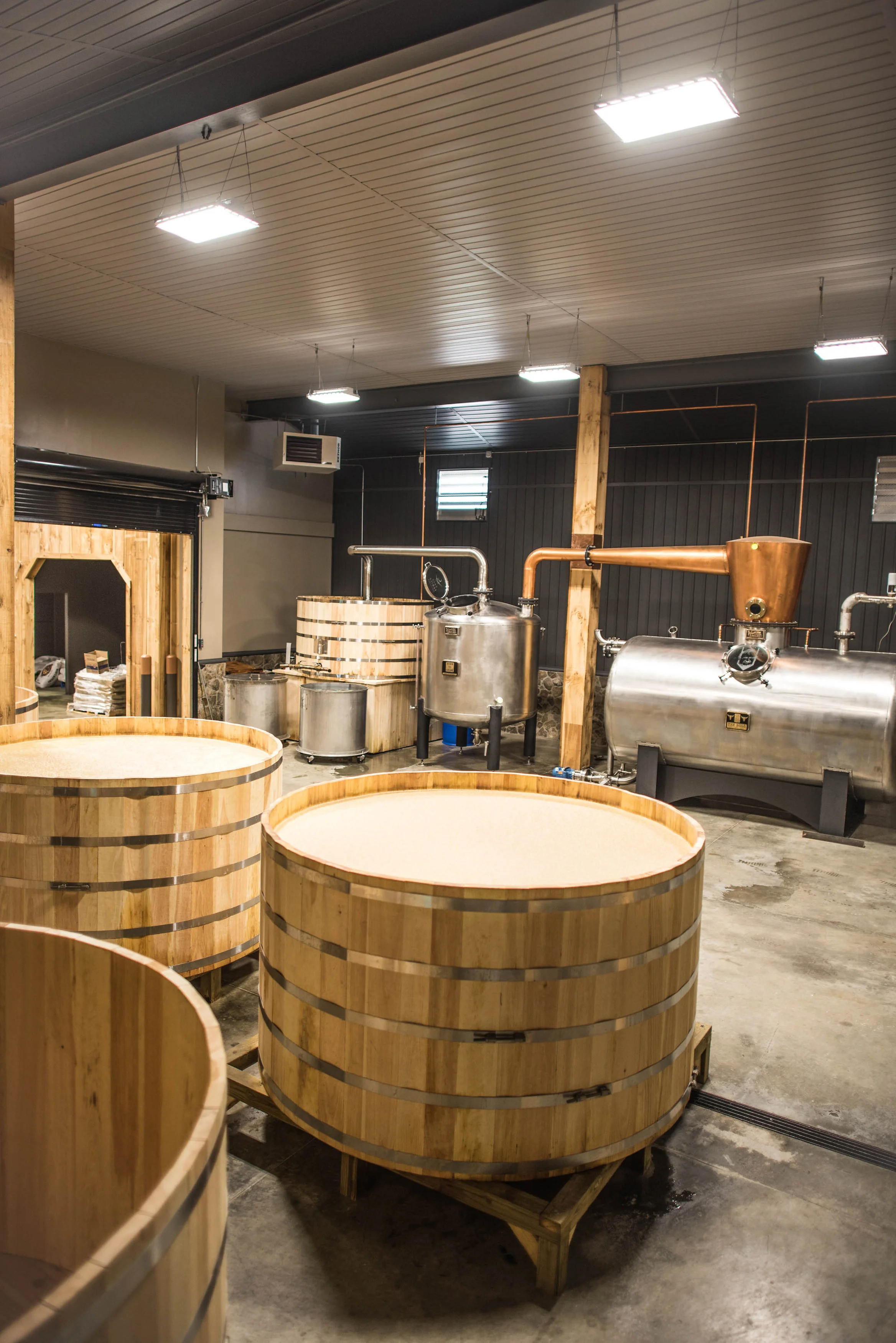 Call Family Distillers stillhouse. 1,000 gallon open fermentation barrels in the front. "The Bull" a 2,100 gallon direct steam injection still in the background.
