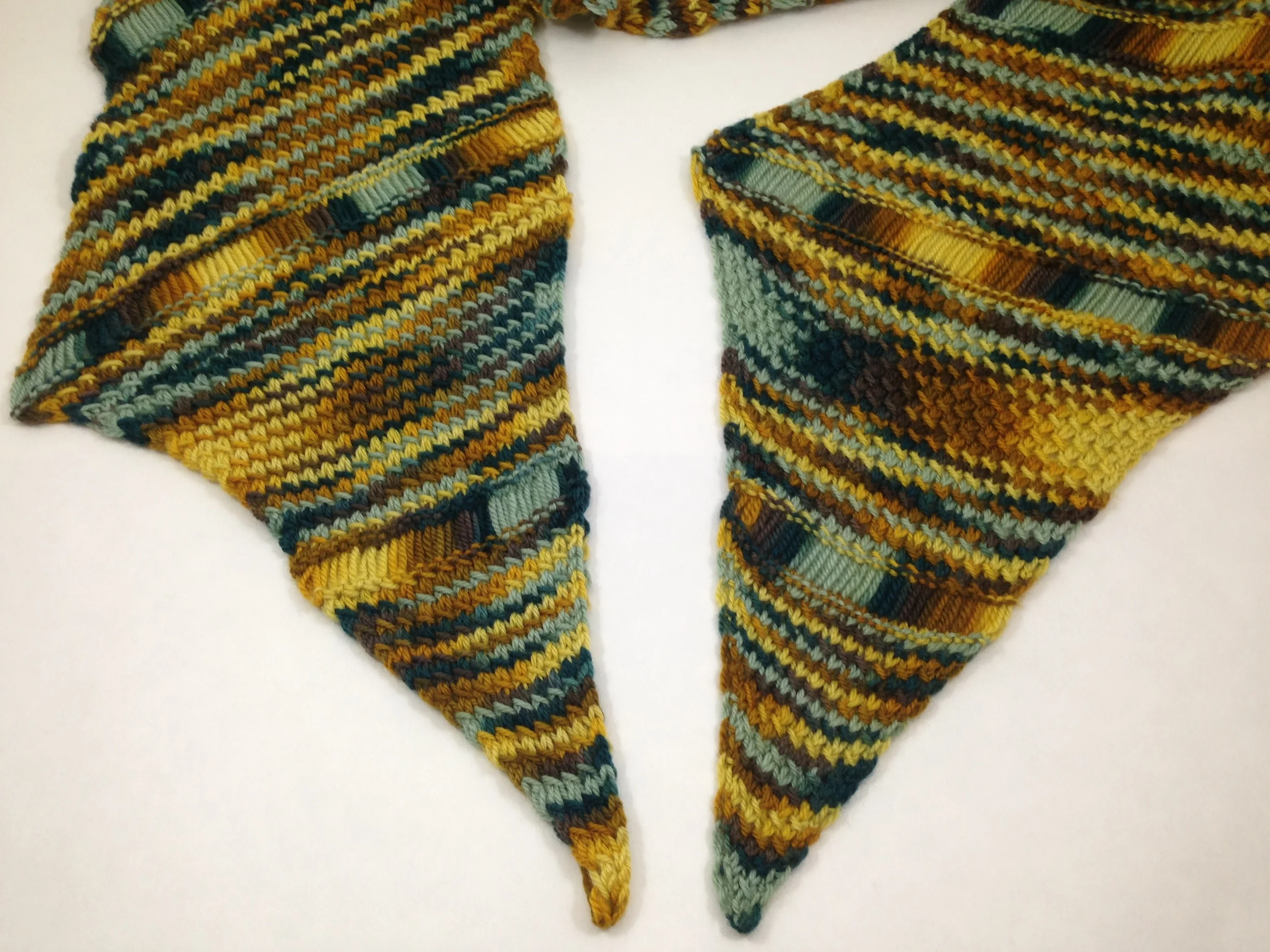 Lay the two ends of the strip next to each other with both points facing toward you, and the right sides facing up. Make sure and line up the dropped stitch sections.