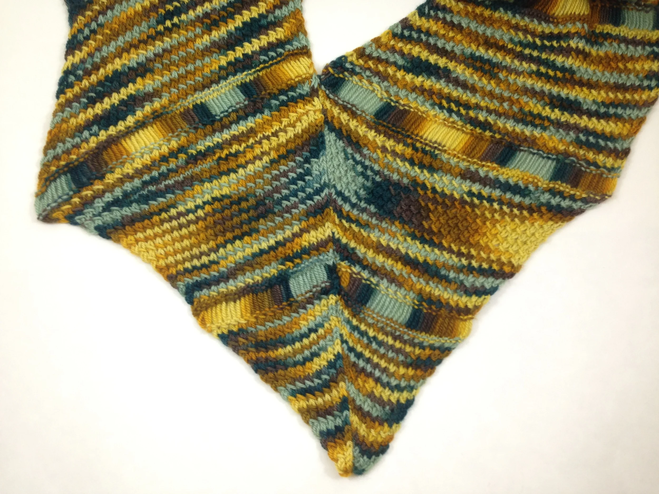 Seam together the right side of one edge and the left side of the other, creating a large triangular point. This creates a bandana style cowl with a point on one end!