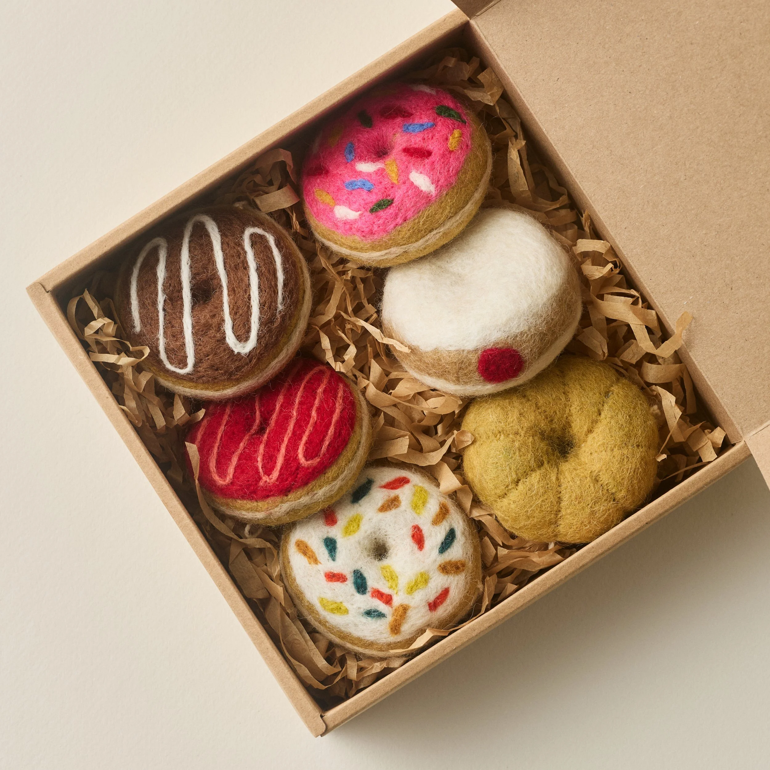 PetitFelts Donut Christmas ornament set with box open to reveal 6 felted donut ornaments