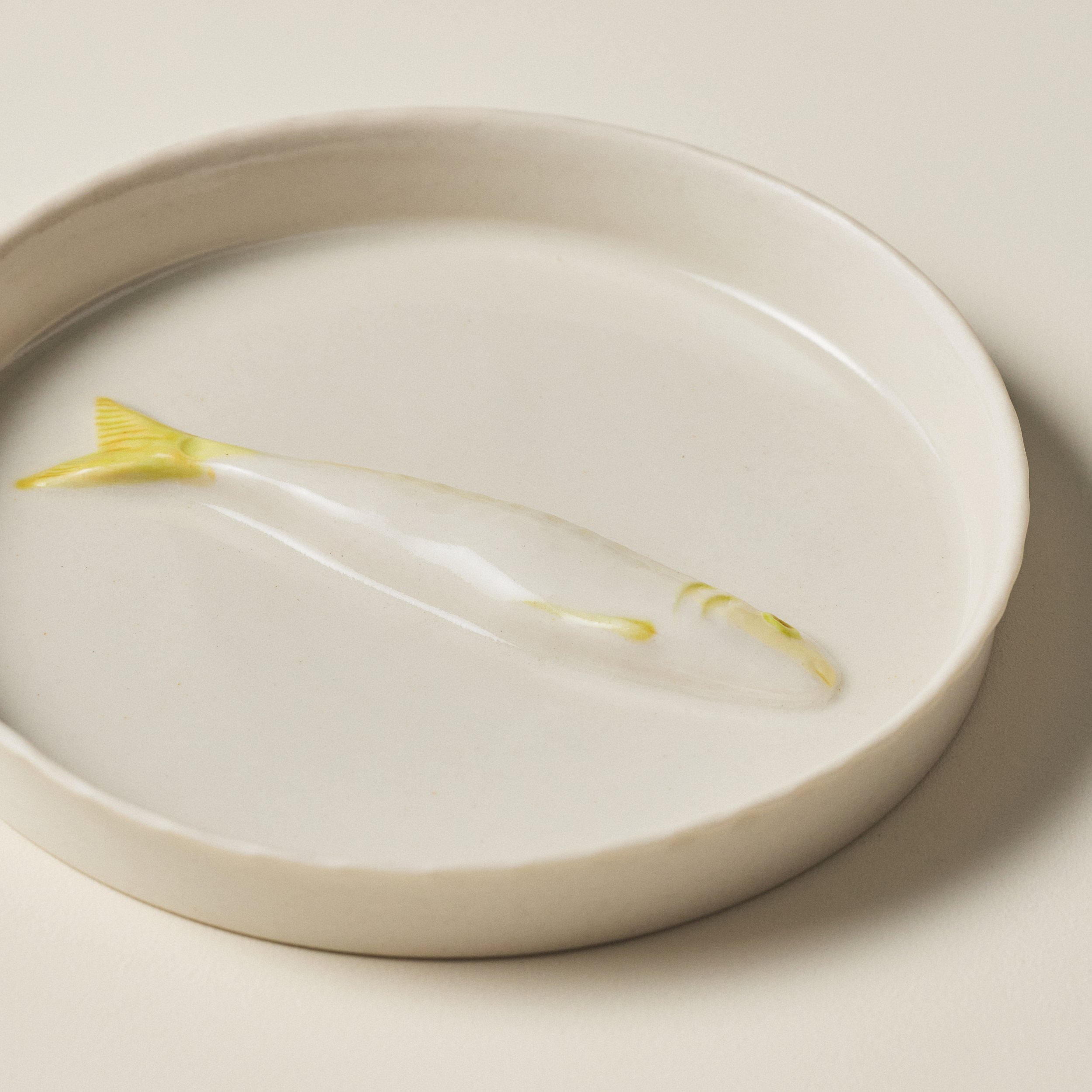 Overhead detail of the PetitFelts Little Julian Moonflower ceramic jewelry tray and sardine sculpture