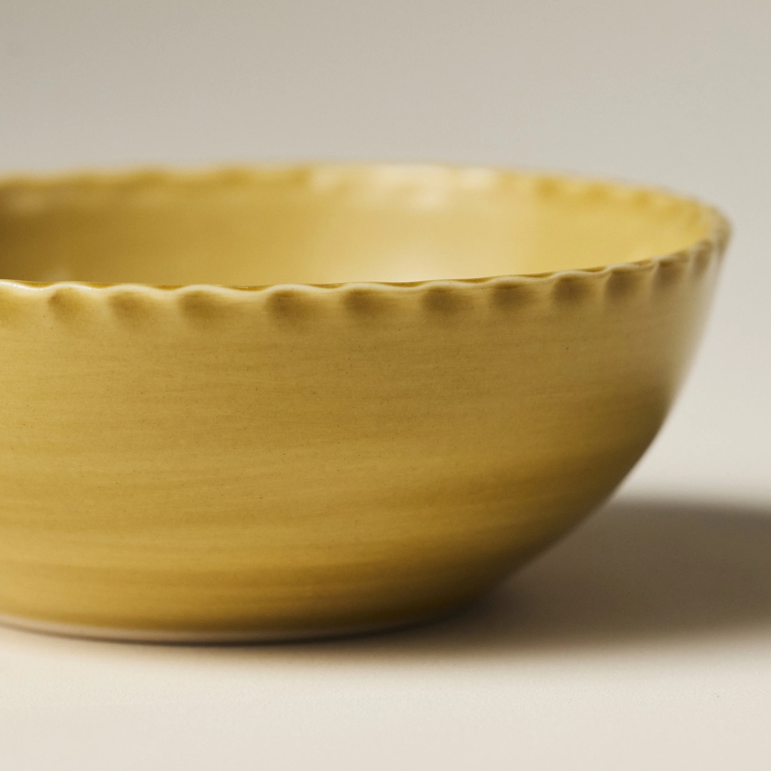 Front view of the PetitFelts Fennel ceramic soup bowl showing its fluted rim