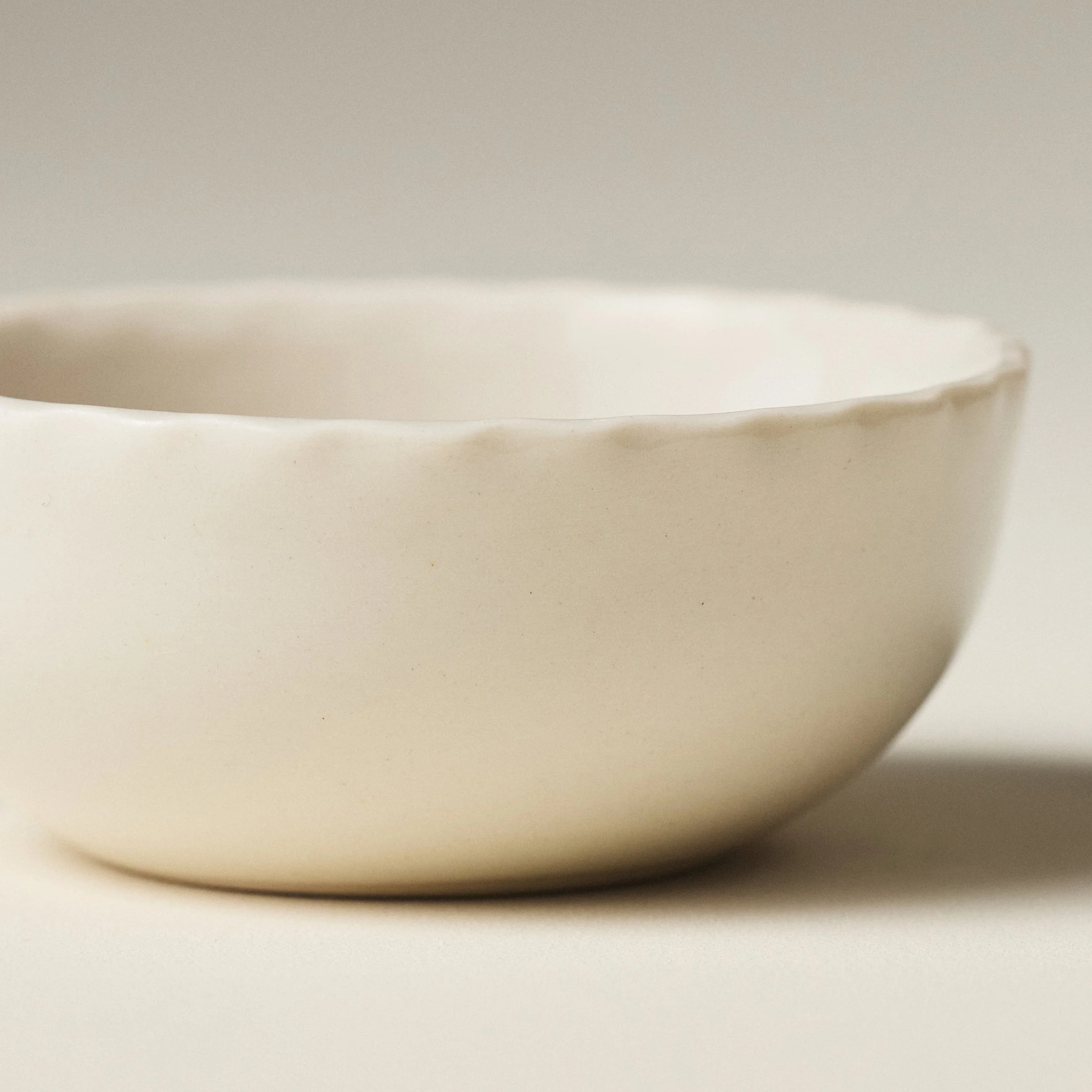 Front view of the PetitFelts Natural small ceramic bowl showing its fluted rim