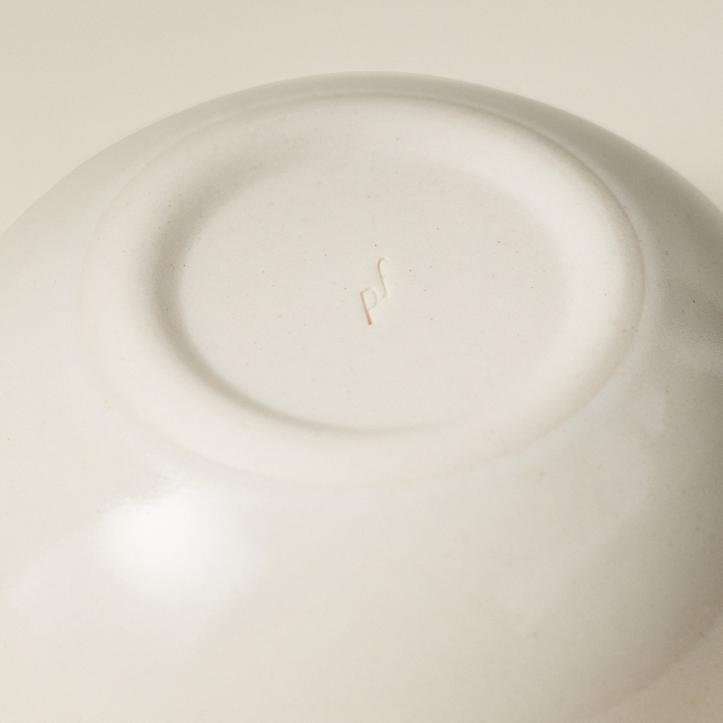 Underside detail of the PetitFelts Natural small ceramic bowl showing the maker's mark