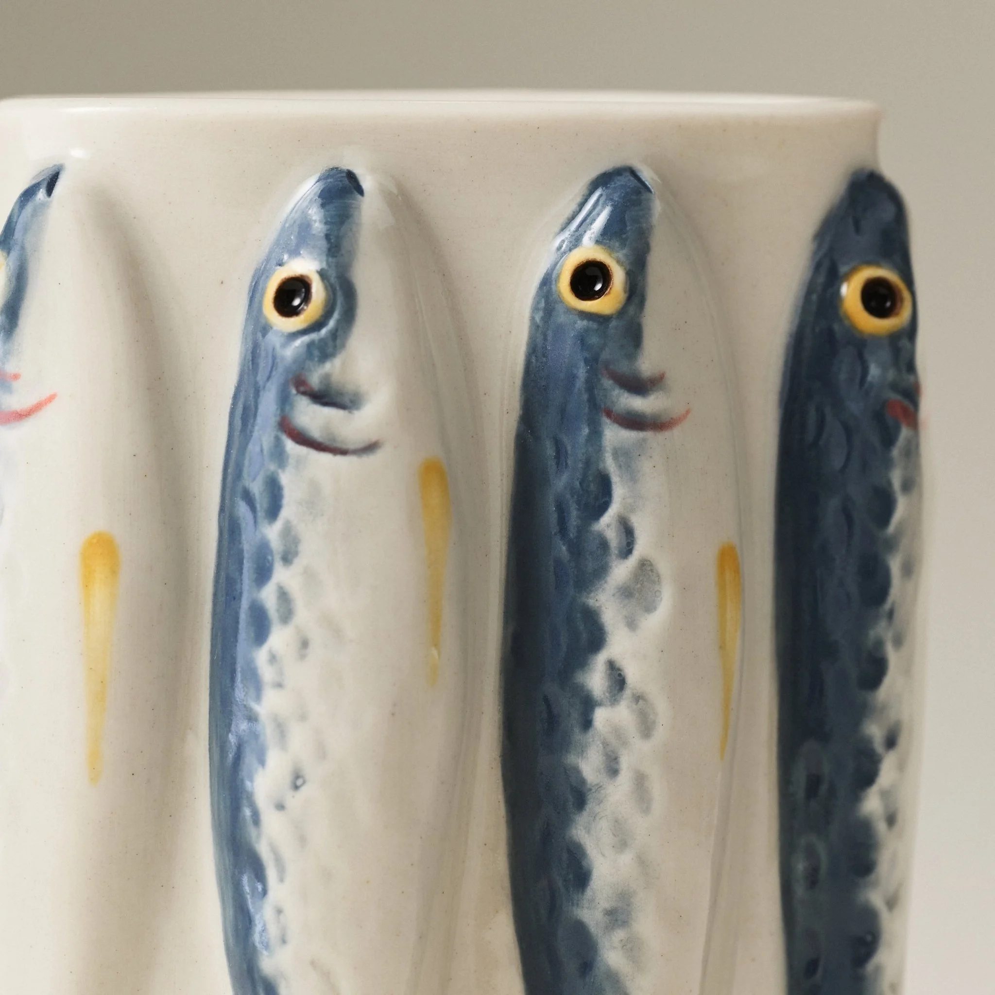 Close-up detail of the PetitFelts Julian ceramic vase's hand-painted sardine faces