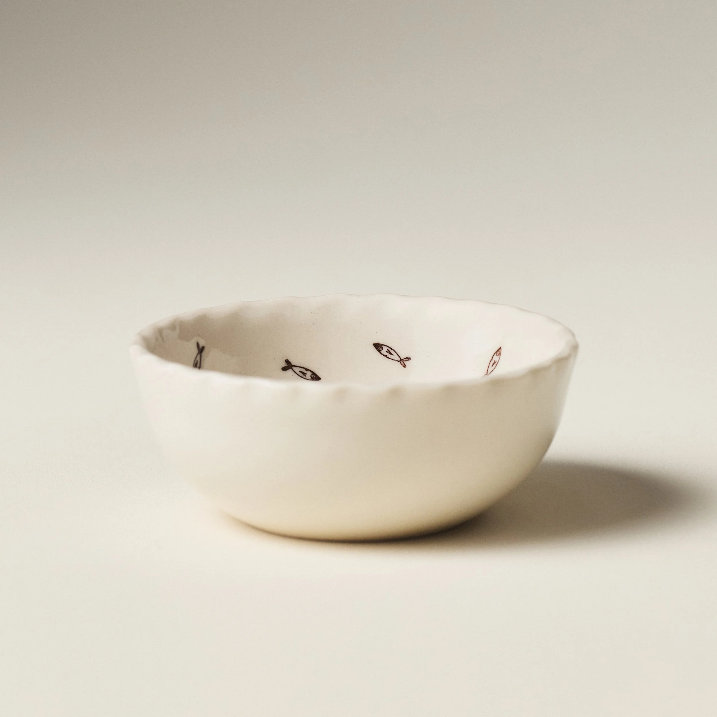 Front view of the PetitFelts Petite Bowl Julian stamp in Natural glaze showing its scalloped rim