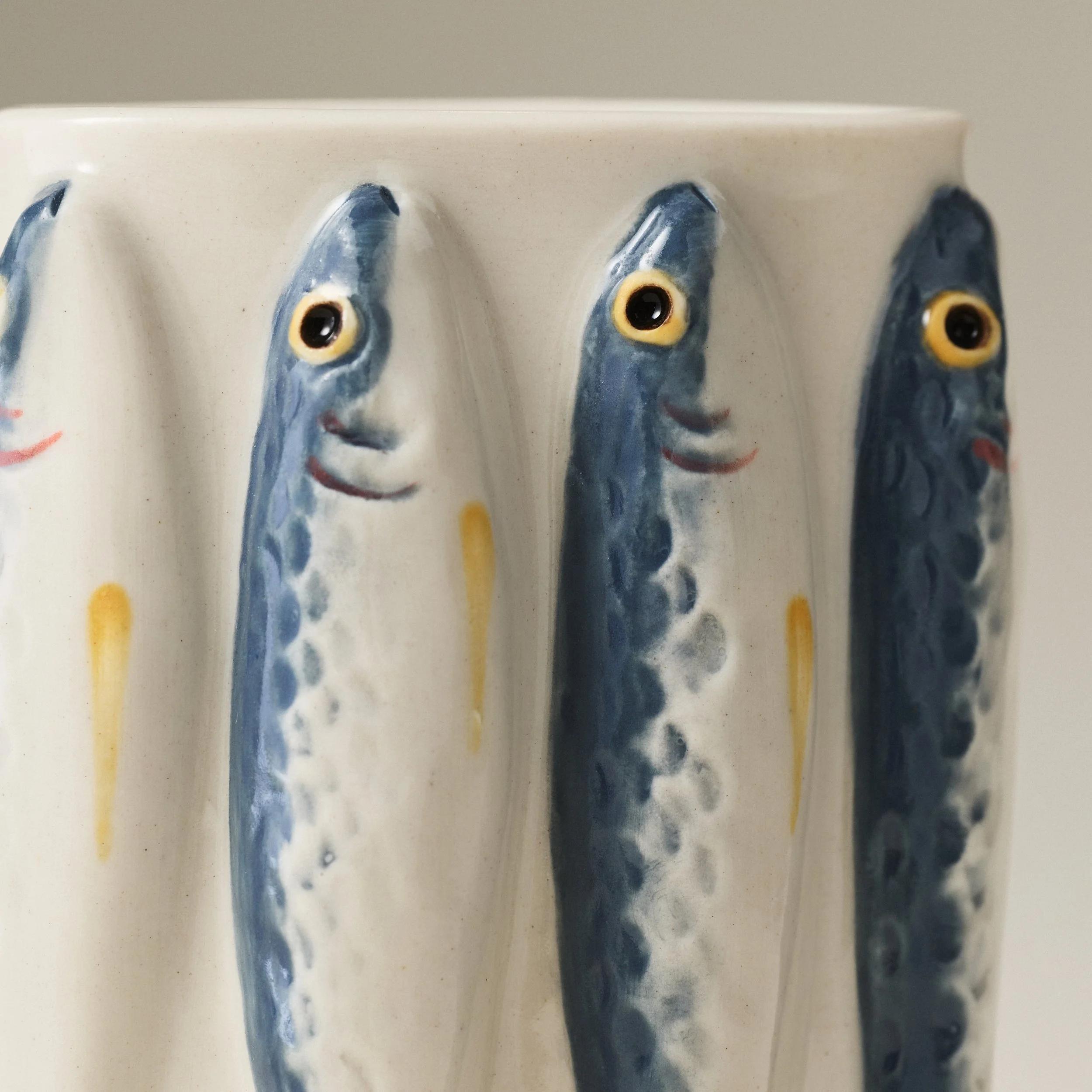 Close-up detail of the PetitFelts Julian ceramic vase's hand-painted sardine faces