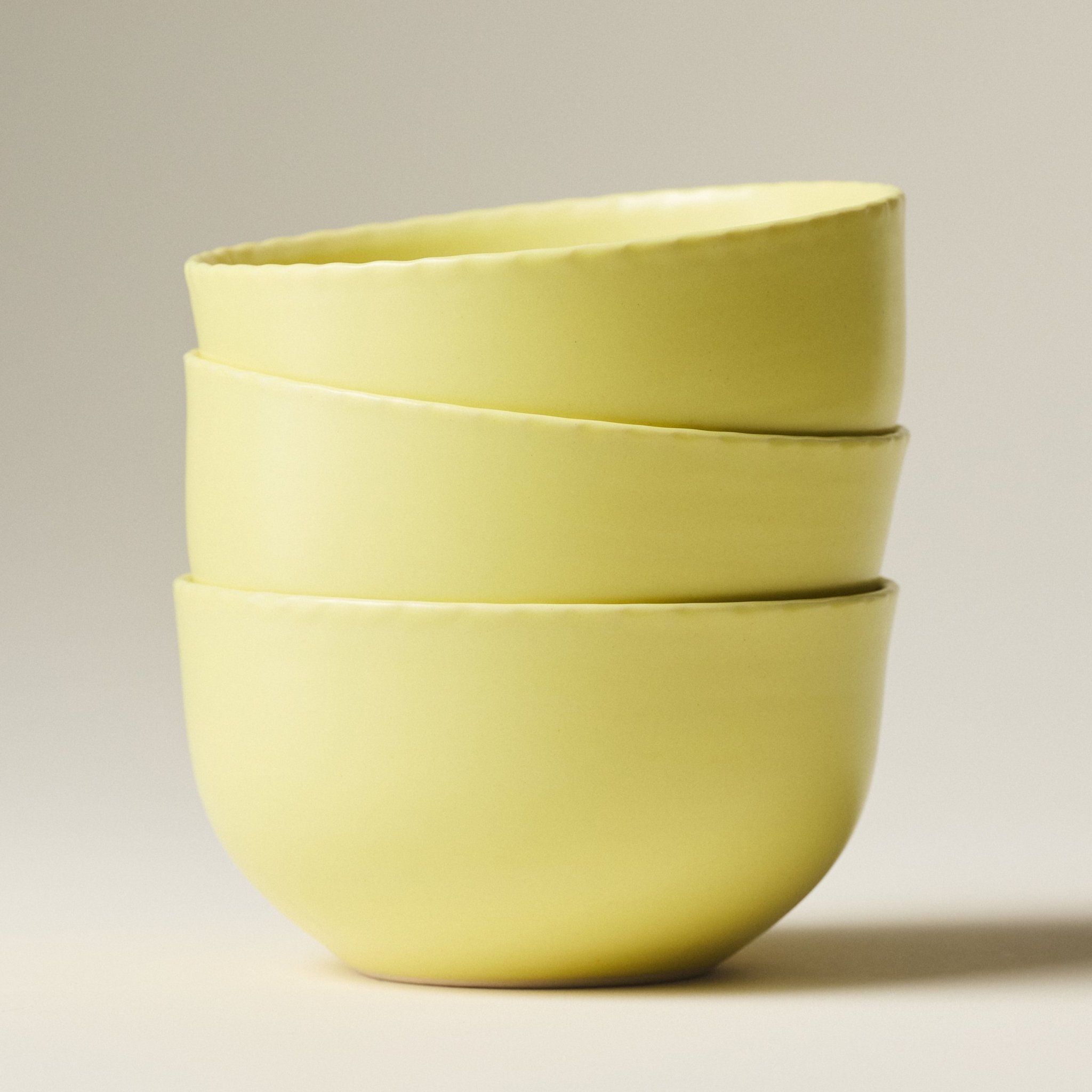 PetitFelts Custard yellow ceramic dinner bowls stacked, showing rim detail and depth