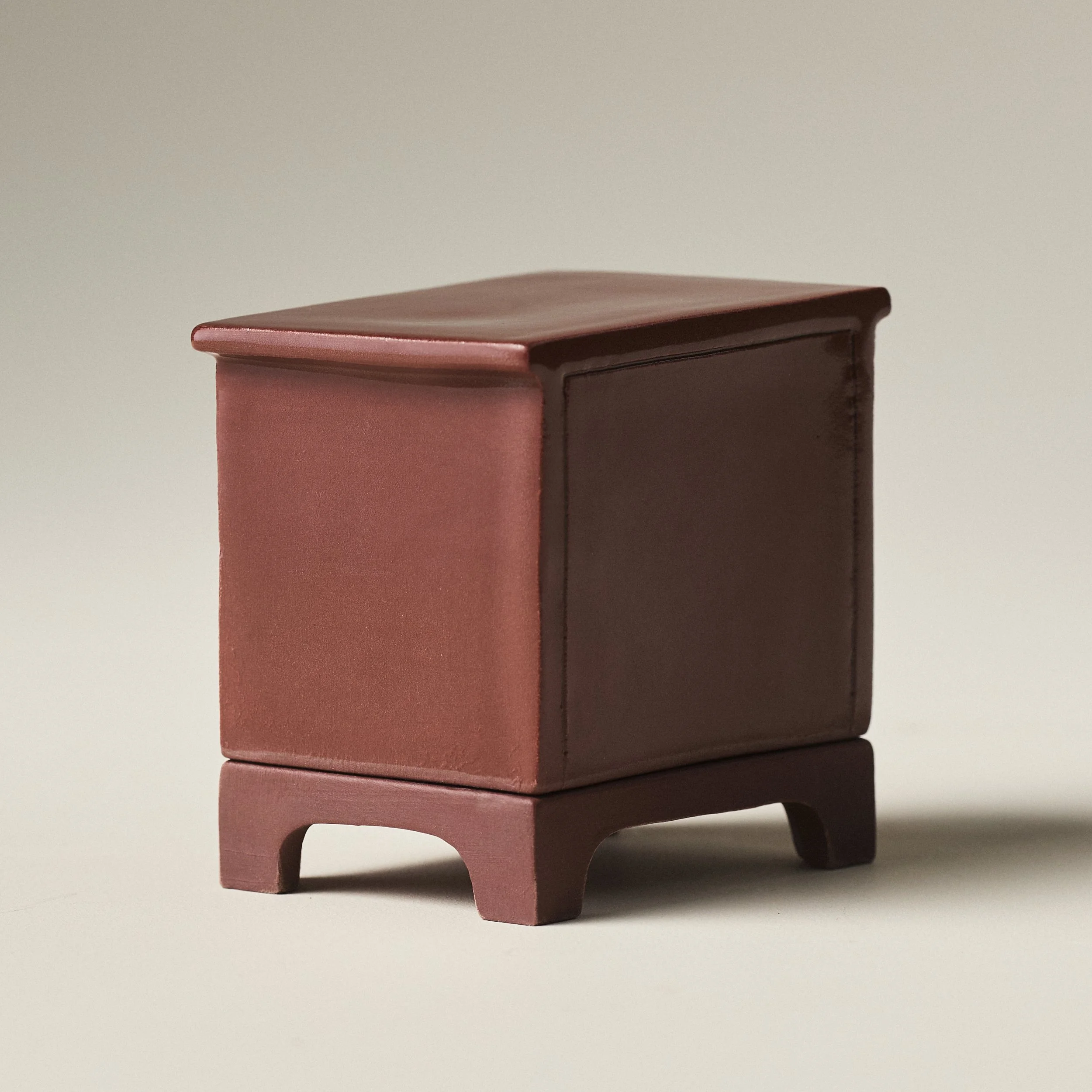 Three-quarter angle view of a closed porcelain dresser match holder and striker