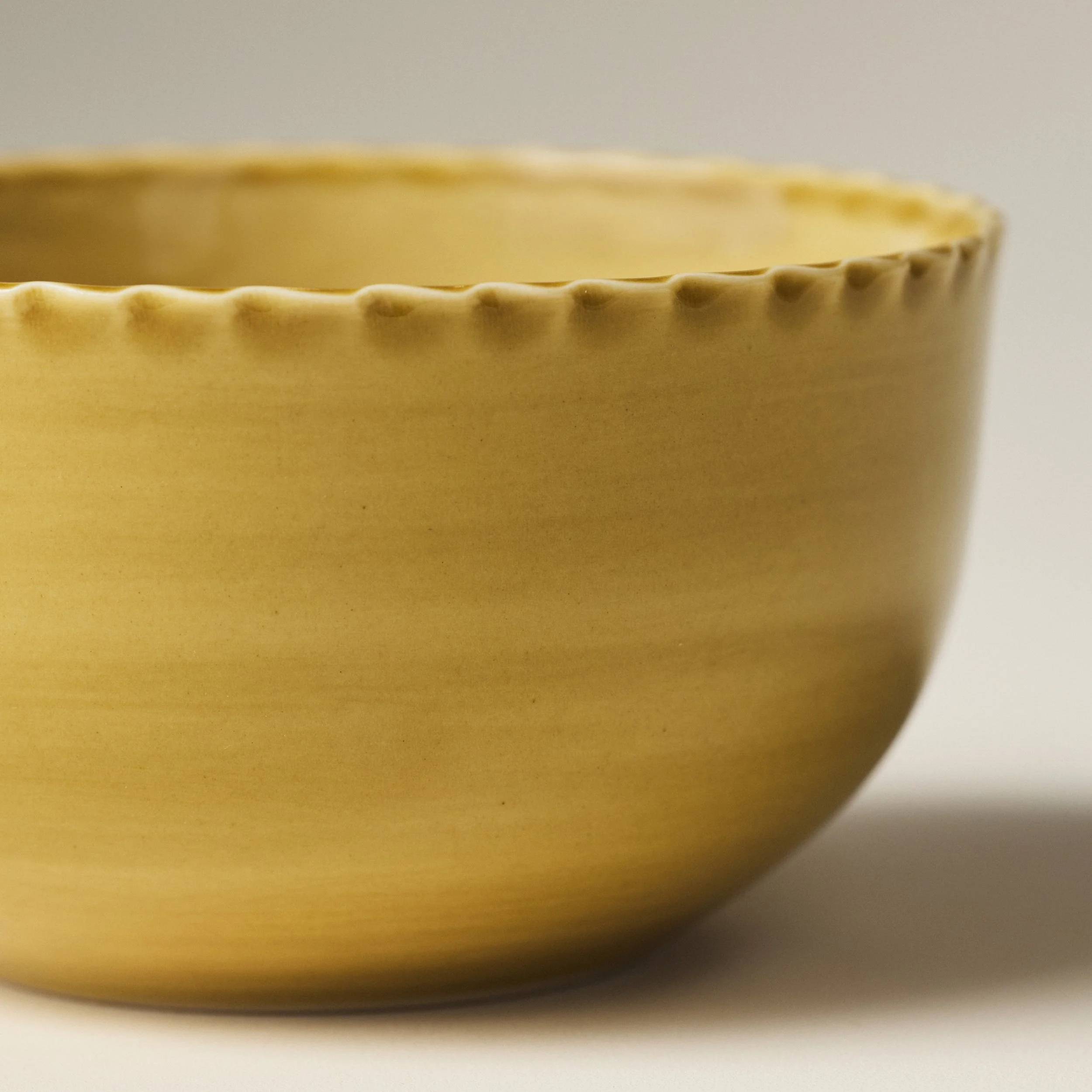 Front view of the PetitFelts Fennel ceramic dinner bowl showing its fluted rim