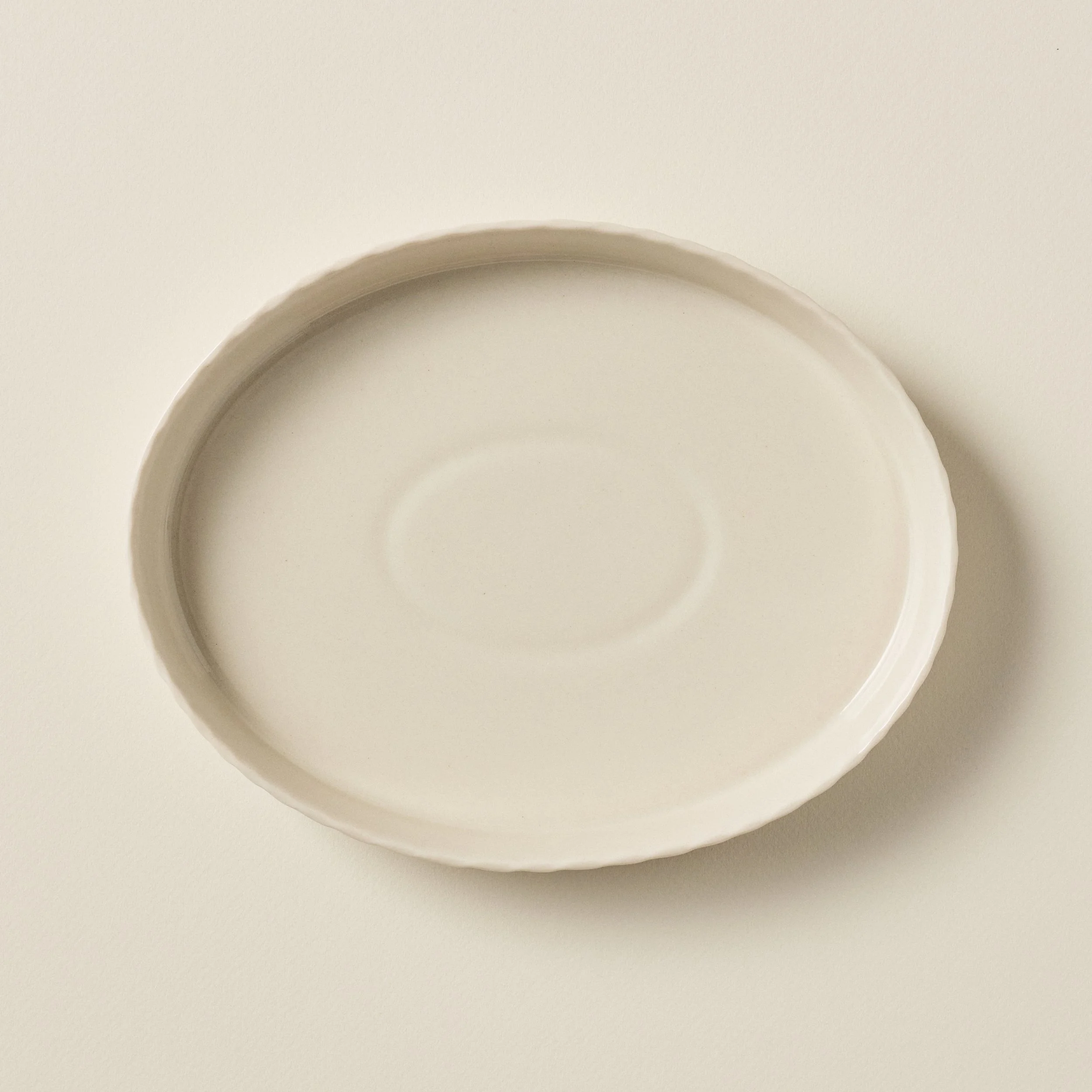 Overhead view of the PetitFelts Natural ceramic platter's glazed interior