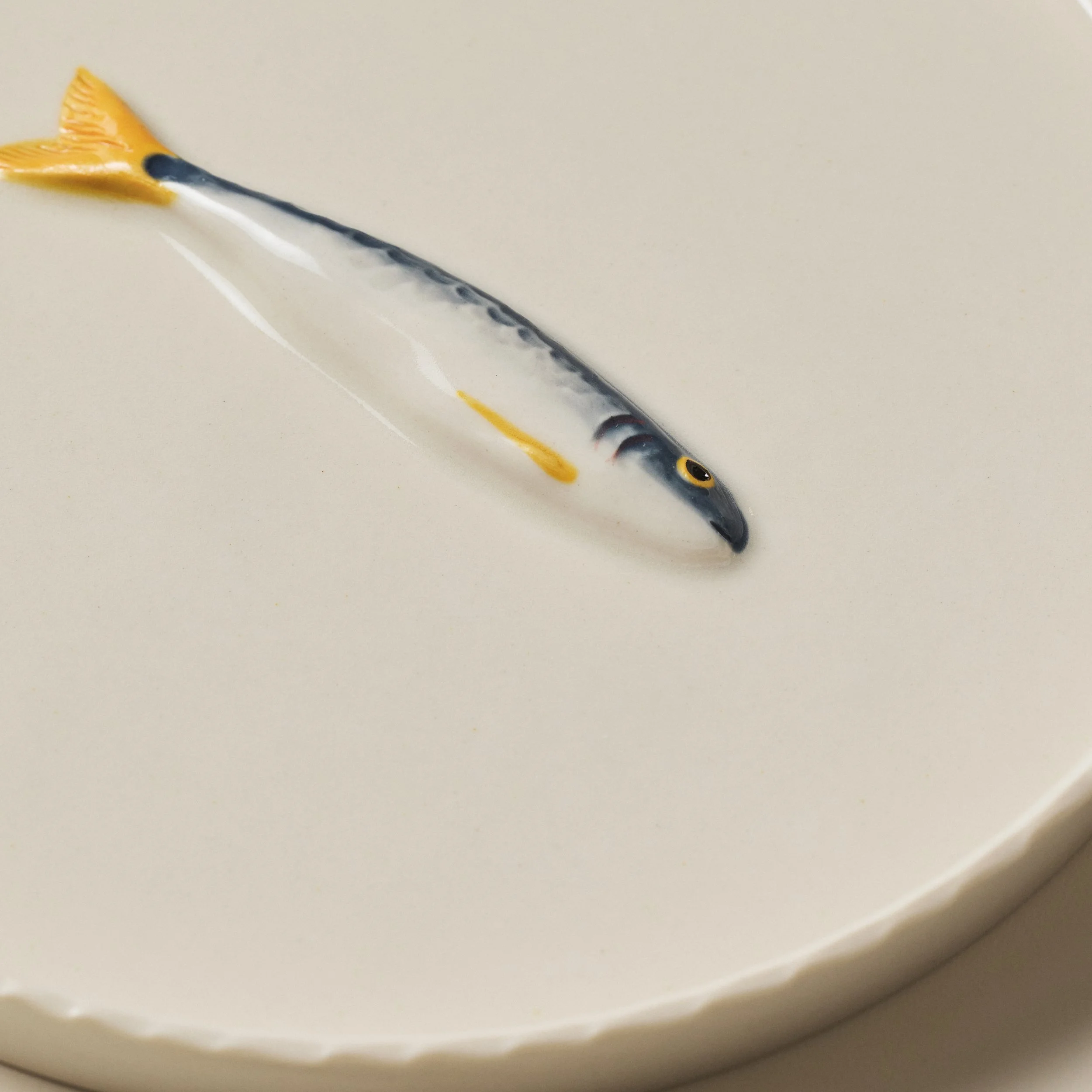Overhead detail of the PetitFelts Big Julian ceramic tray and sardine sculpture