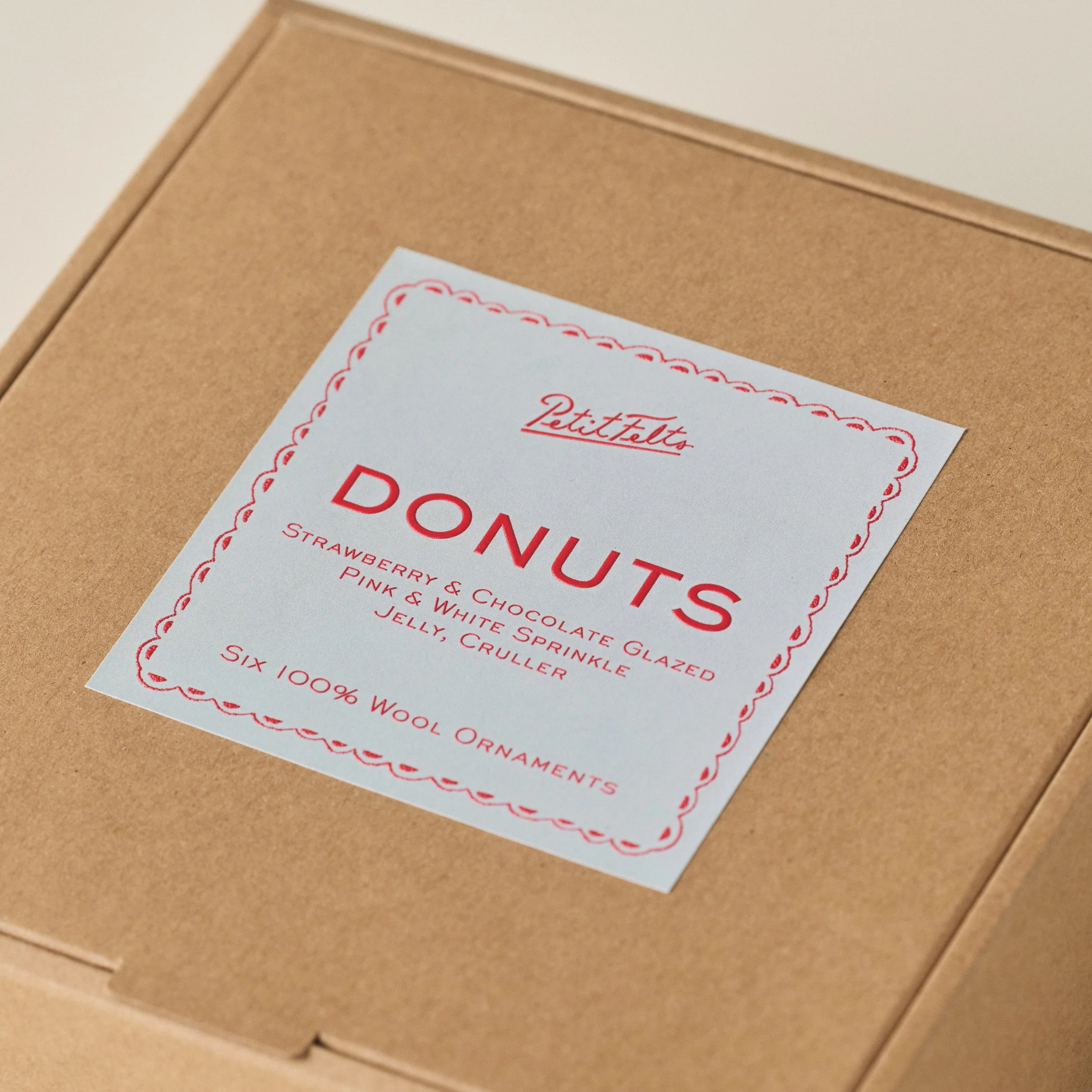 PetitFelts Donut Christmas ornament set lable detail with light blue label and vermillion raised ink text