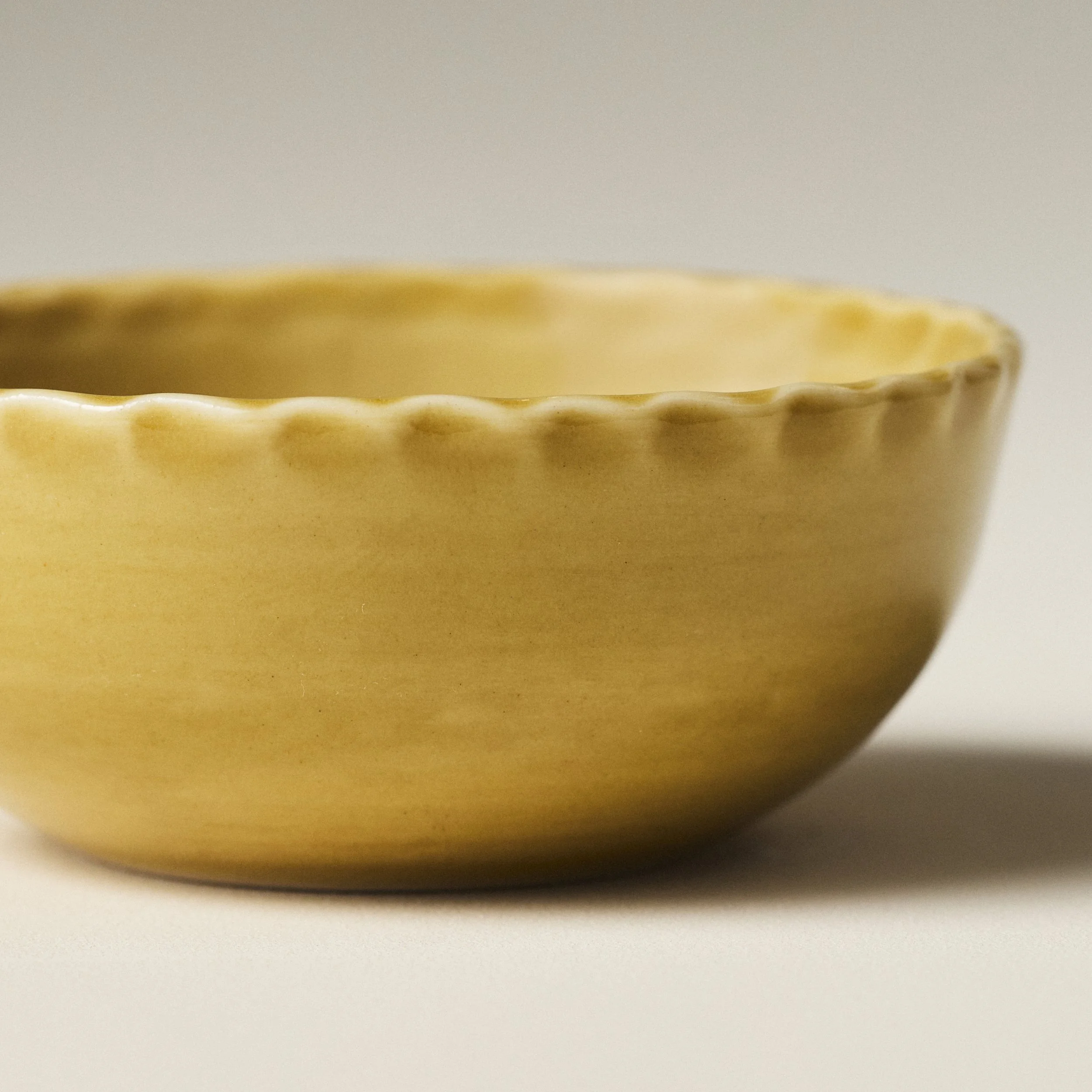 Front view of the PetitFelts Fennel small ceramic bowl showing its fluted rim