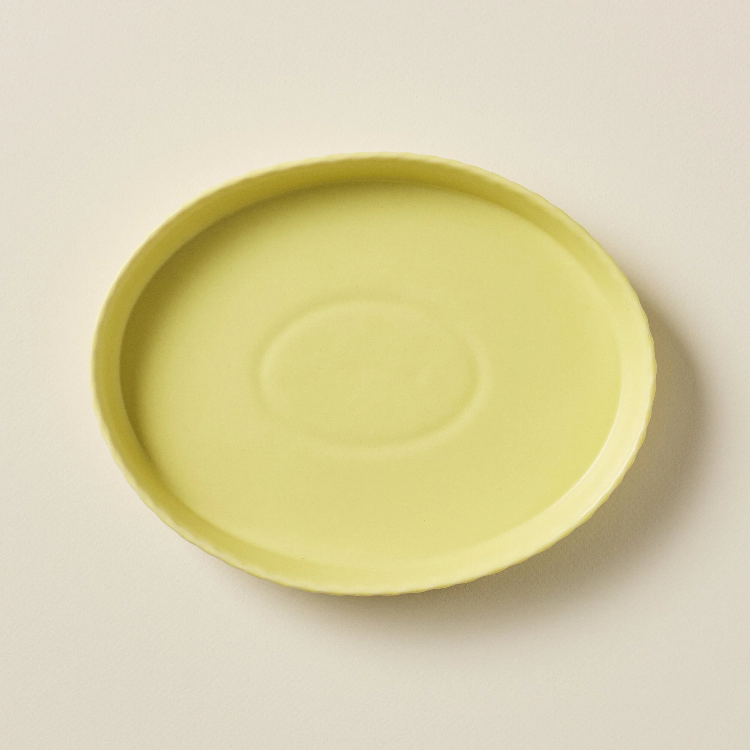 Overhead view of the PetitFelts Custard ceramic platter's glazed interior