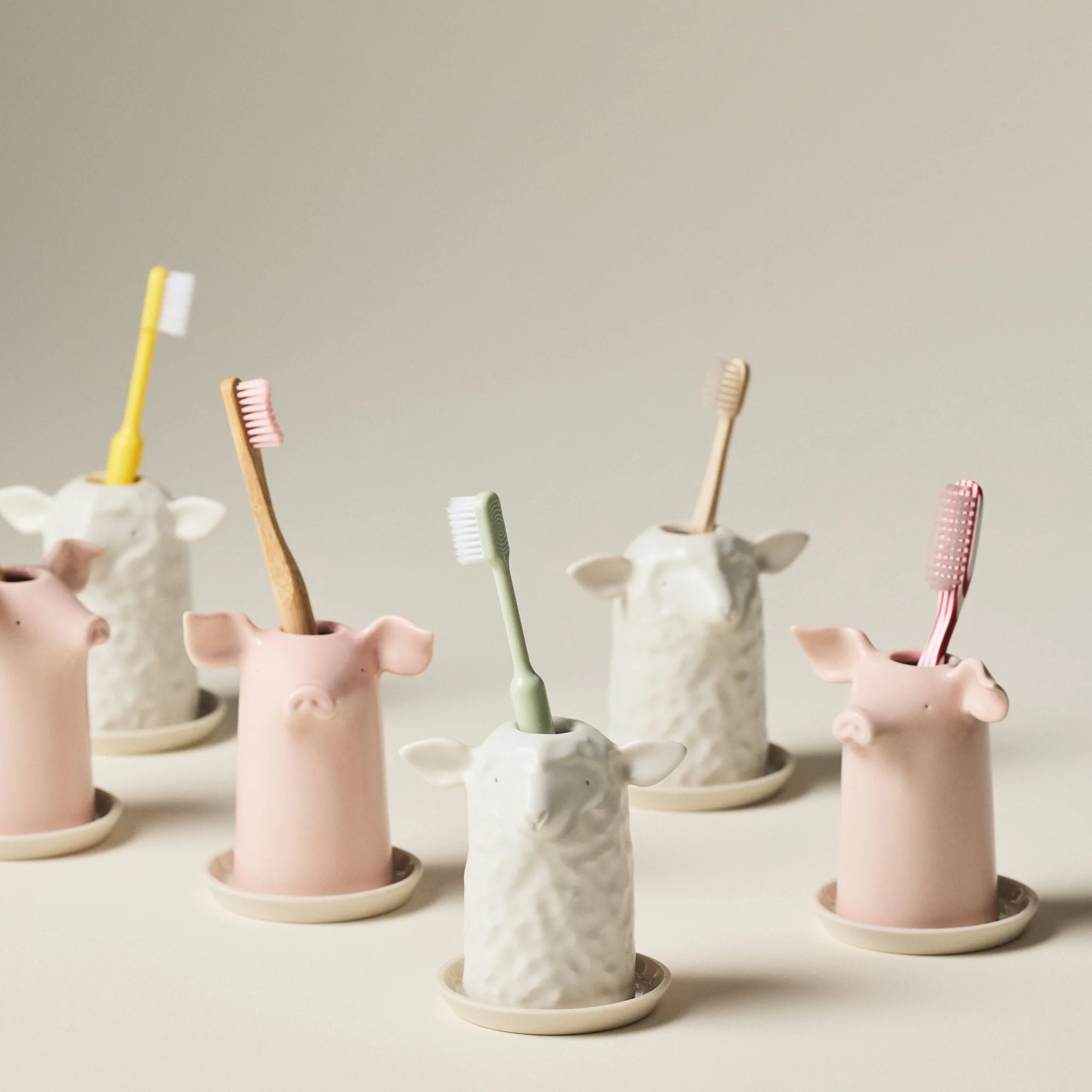 Row of PetitFelts Herschel and Rose toothbrush holders, each holding a toothbrush