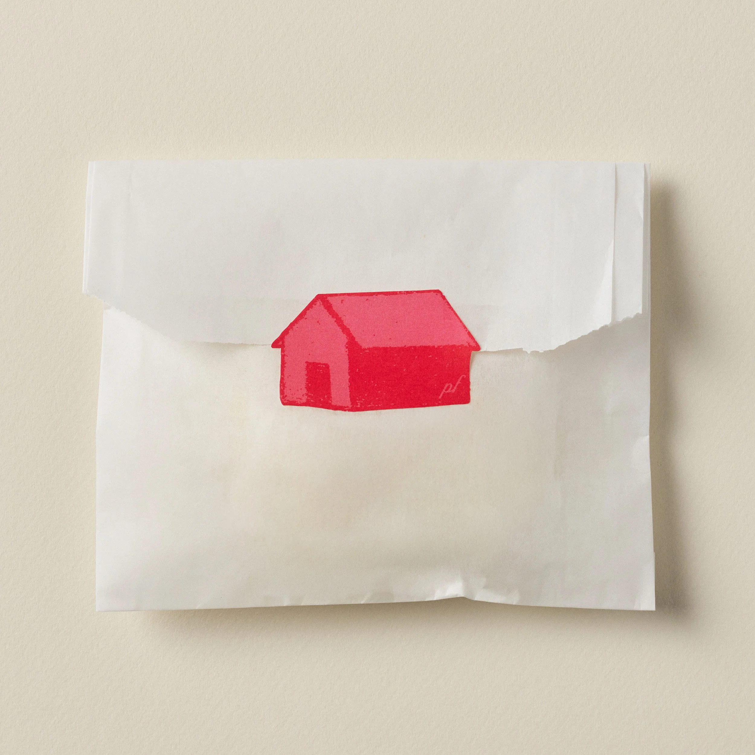 Ornament shipped in a simple white sleeve sealed with a red house sticker