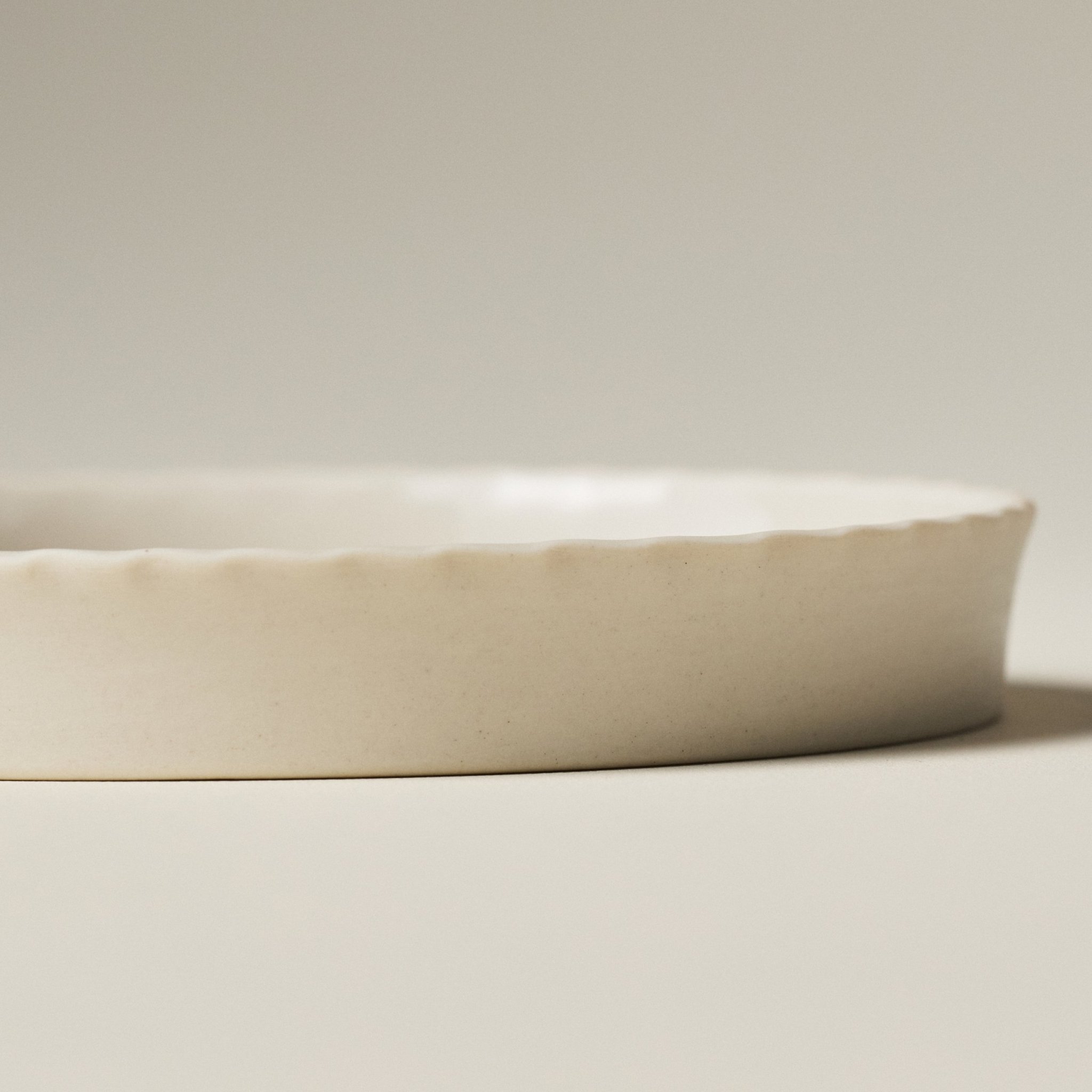Side view of the PetitFelts Little Julian ceramic tray showing its rim