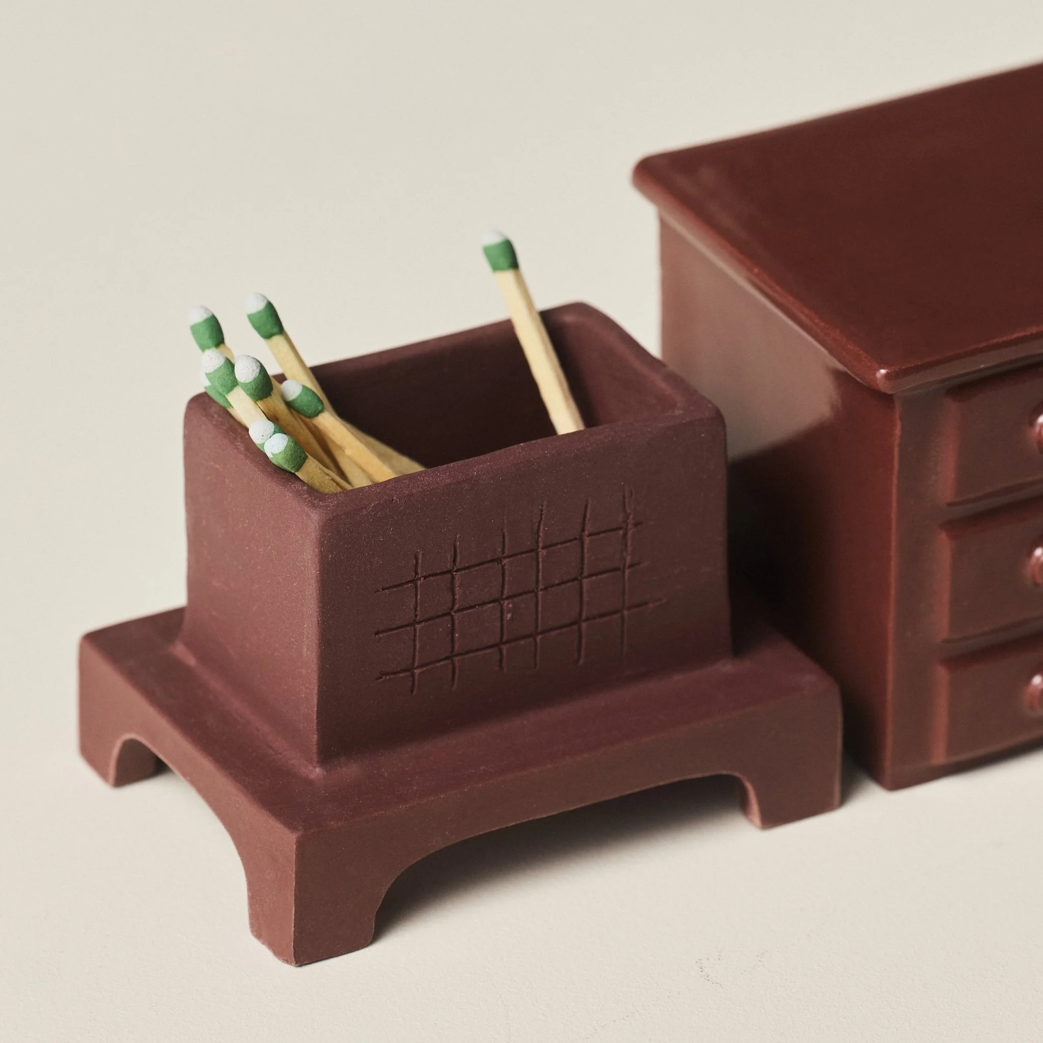 Open porcelain match holder  filled with matches beside the top