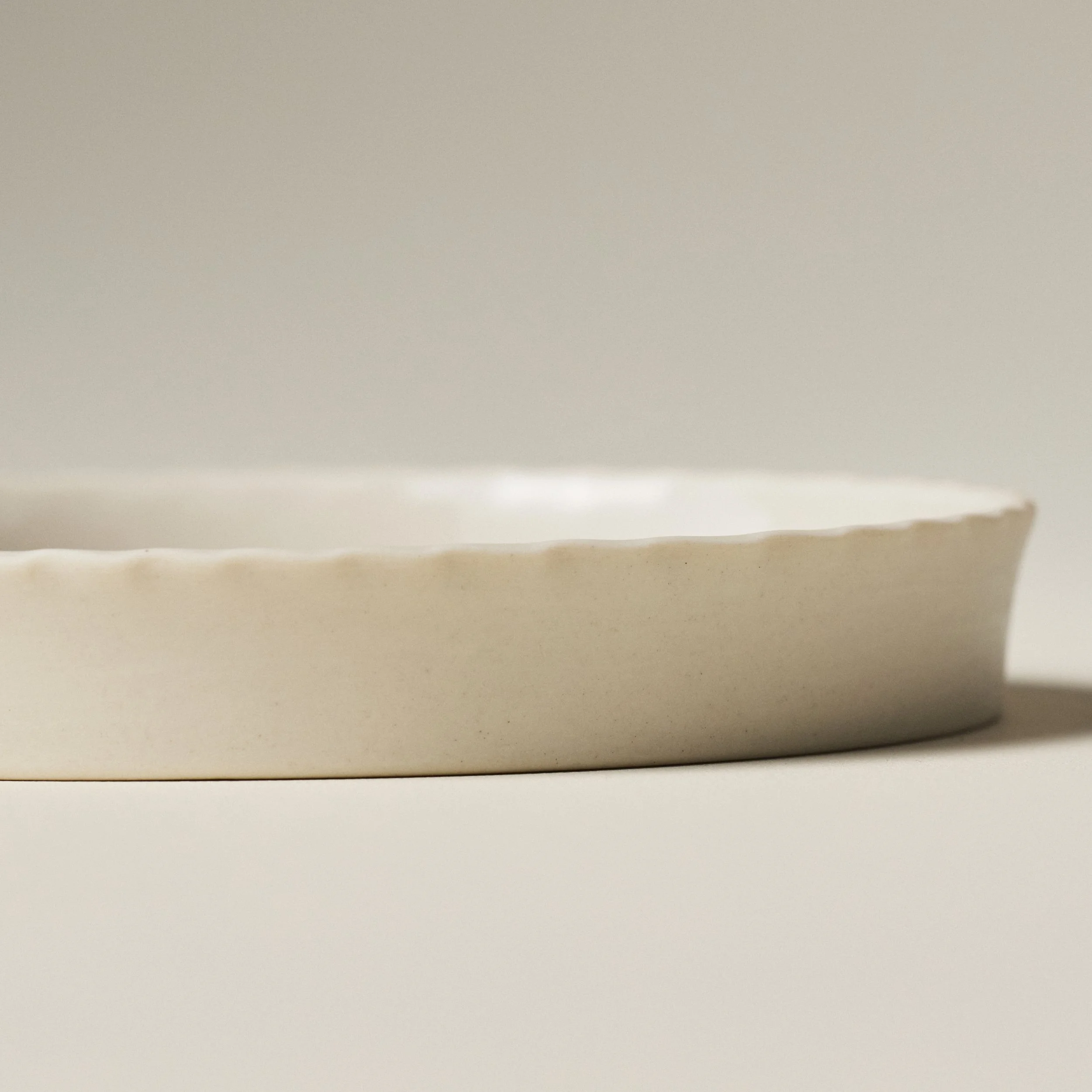 Side view of the PetitFelts Little Julian ceramic tray showing its rim