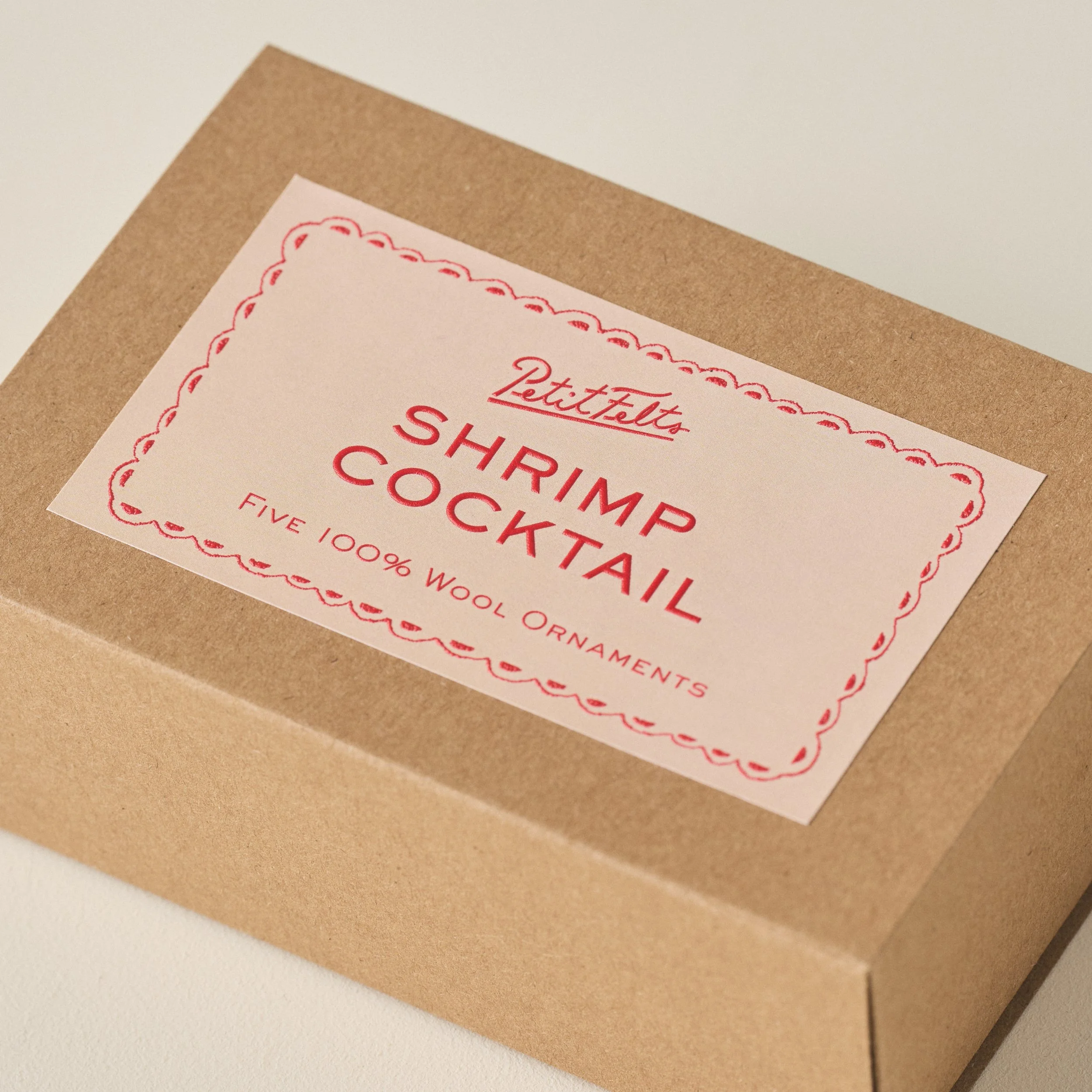PetitFelts Shrimp Christmas ornament box detail with sehll pink background and vermillion raised ink text