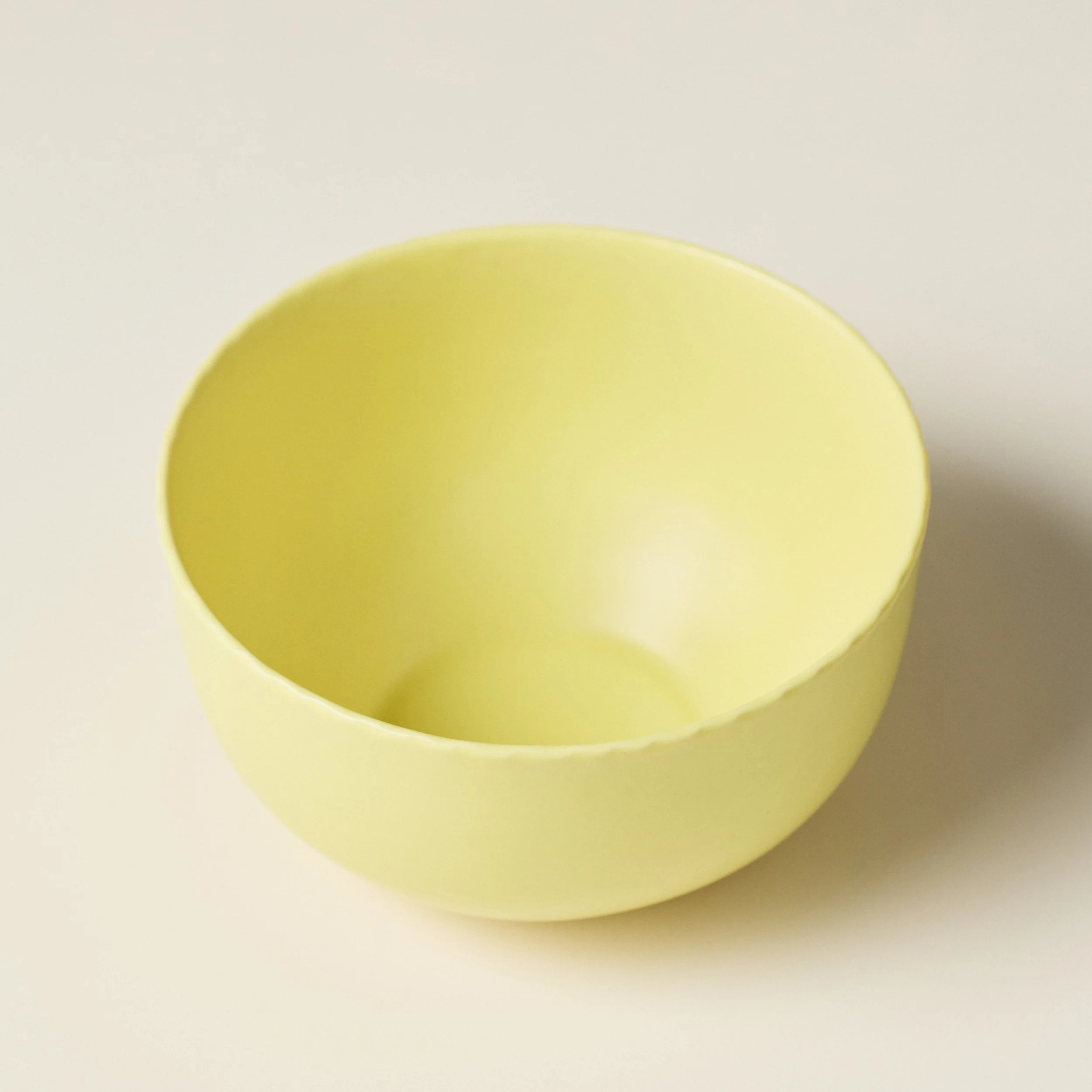 Front view of the PetitFelts Custard ceramic dinner bowl showing its fluted rim