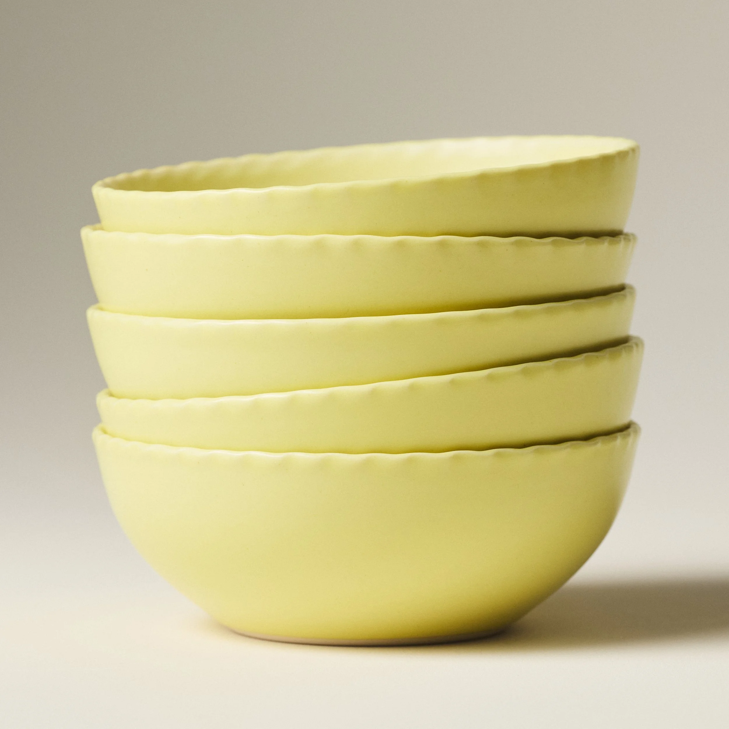 PetitFelts Custard yellow ceramic soup bowls stacked, showing rim detail and depth