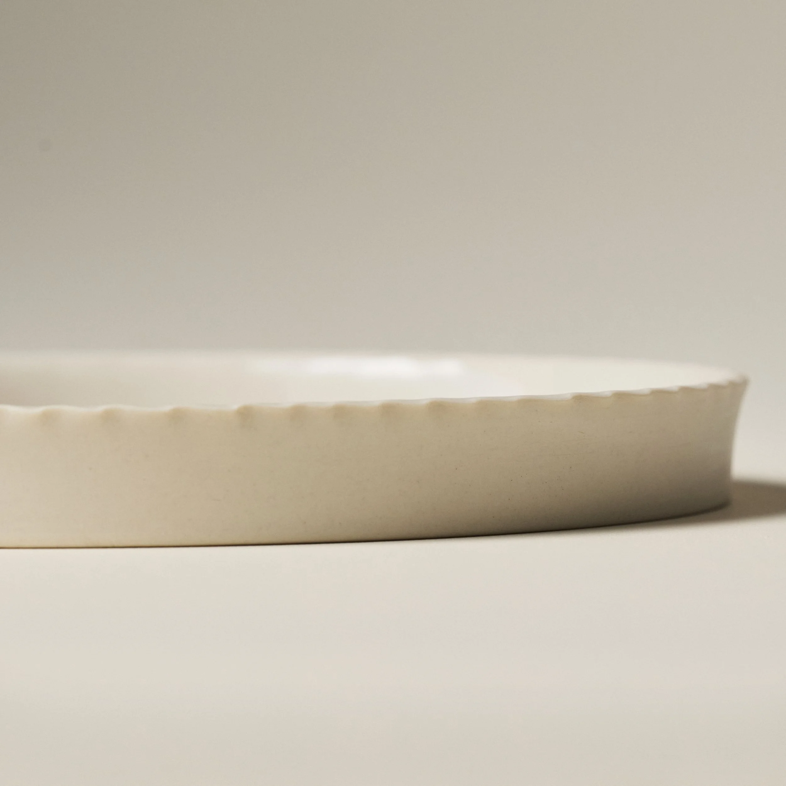 Side view of the PetitFelts Big Julian ceramic serving tray showing its rim