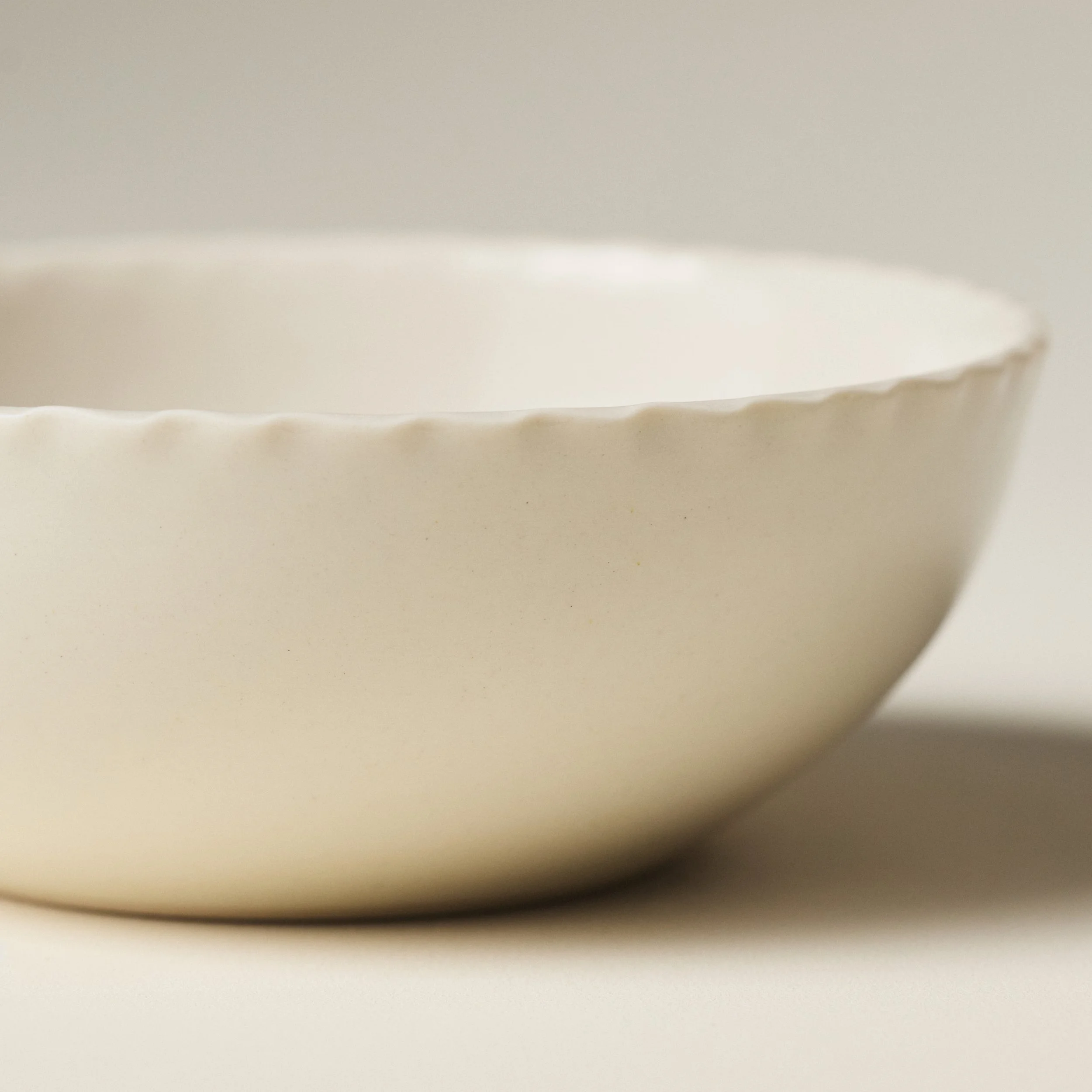 Front view of the PetitFelts Natural ceramic soup bowl showing its fluted rim