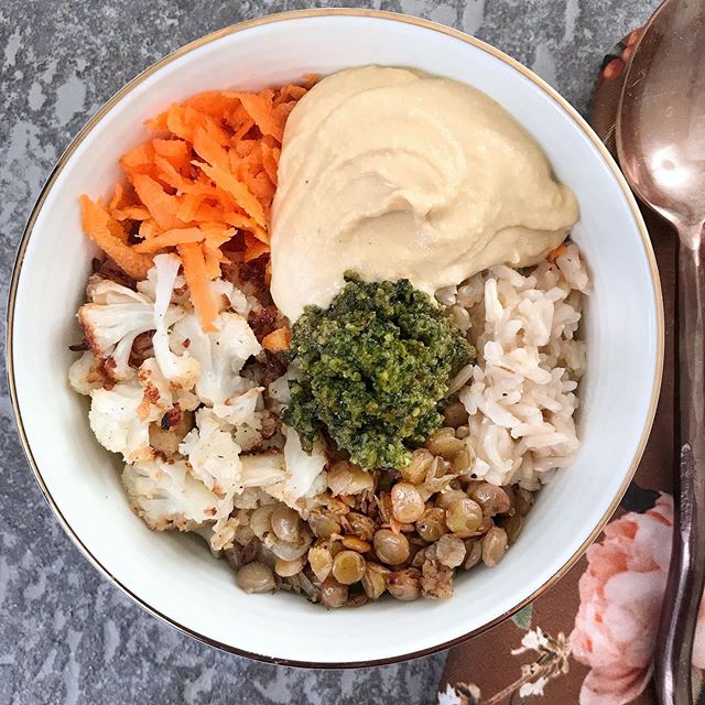 Delightful lunch: brown rice, fried lentils and onions, roasted cauliflower, and grated carrot, topped with homemade hummus and basil kale pesto 😋