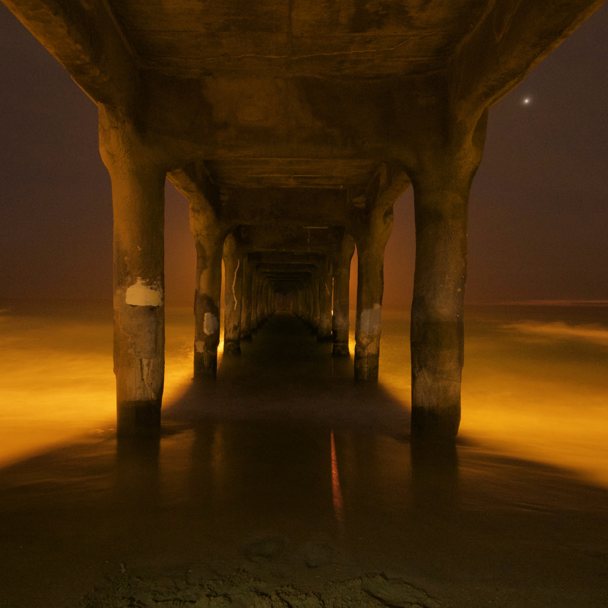Manhattan Beach Pier at midnight. Light is from the pier and the full moon.