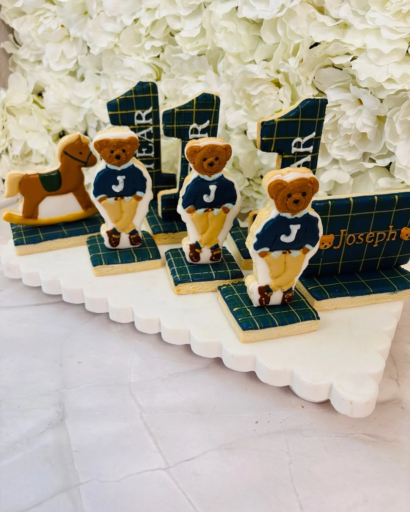 A BEARY special 1st birthday! 🧸💙✨

Celebrating Joseph&rsquo;s big ONE with this beautifully detailed, preppy-inspired custom cookie set! From the adorable Ralph Lauren inspired teddy bears and rocking horse to the personalized plaid details, every 
